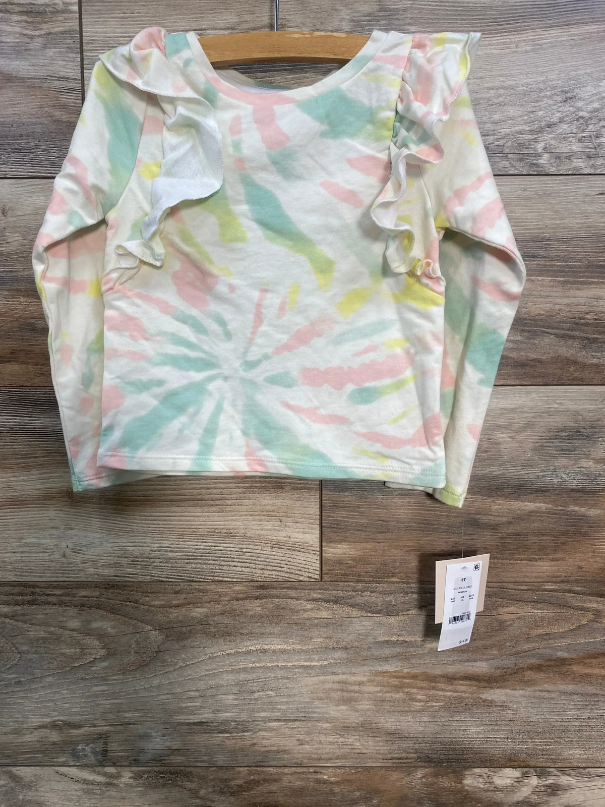 Toddler tie-dye long sleeve shirt with ruffle detail on shoulders, hanging on wooden hanger