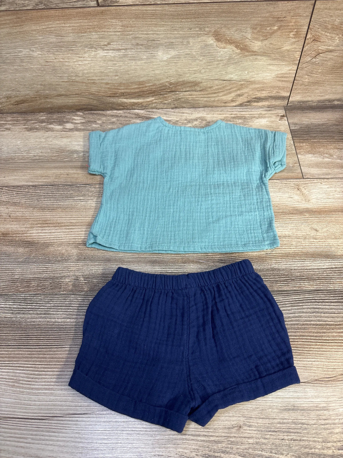 Top view of blue Cat & Jack 2-piece gauze shirt and shorts set with elastic-waist shorts on a wood floor