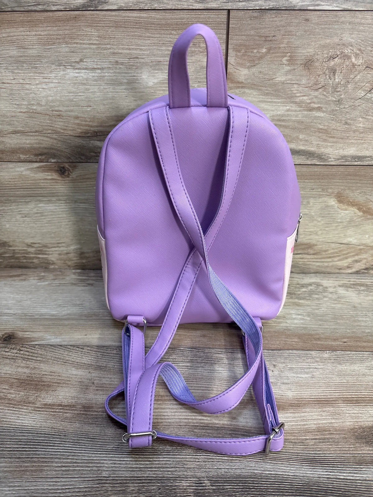 Back view of Five Nights At Freddy’s: Security Breach Chibi Mini Backpack showcasing purple shoulder straps and top handle on a wood-grain background
