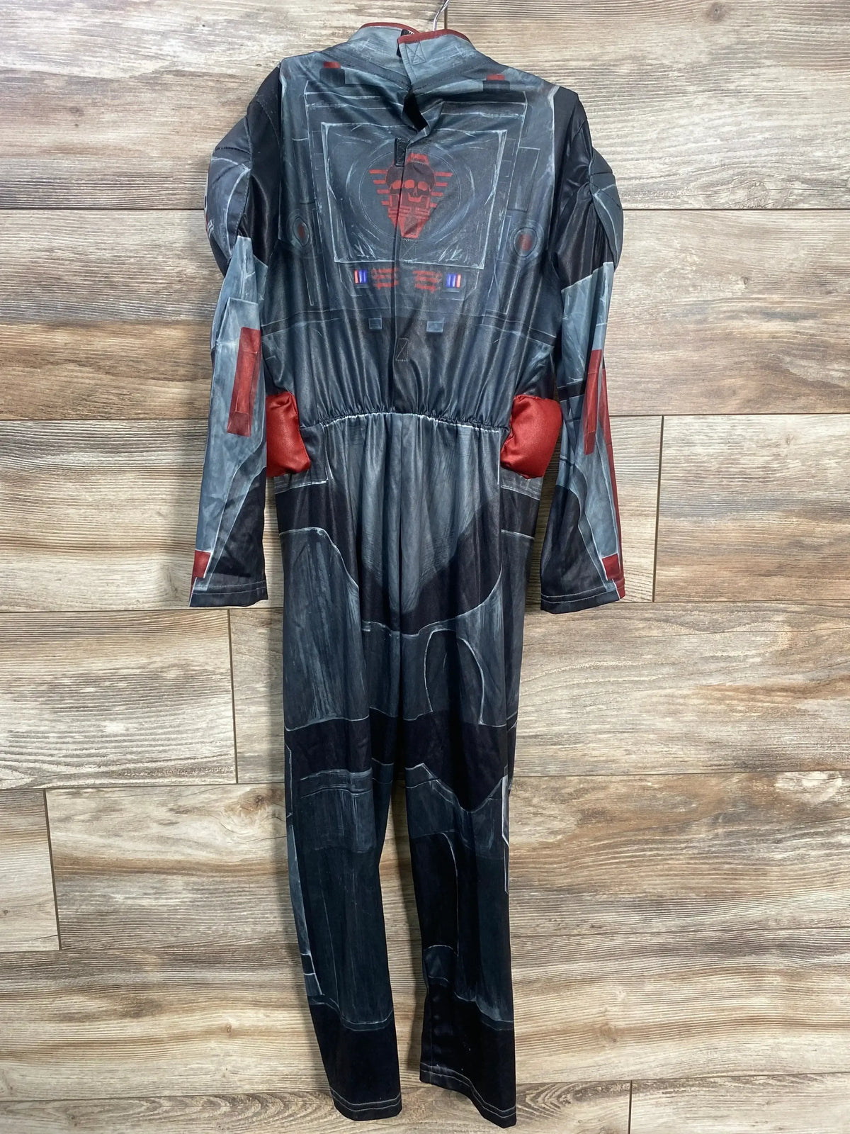 Front view of Disney Store Wrecker costume in black, size 5/6, showcasing printed armor details and red accents on a wood floor
