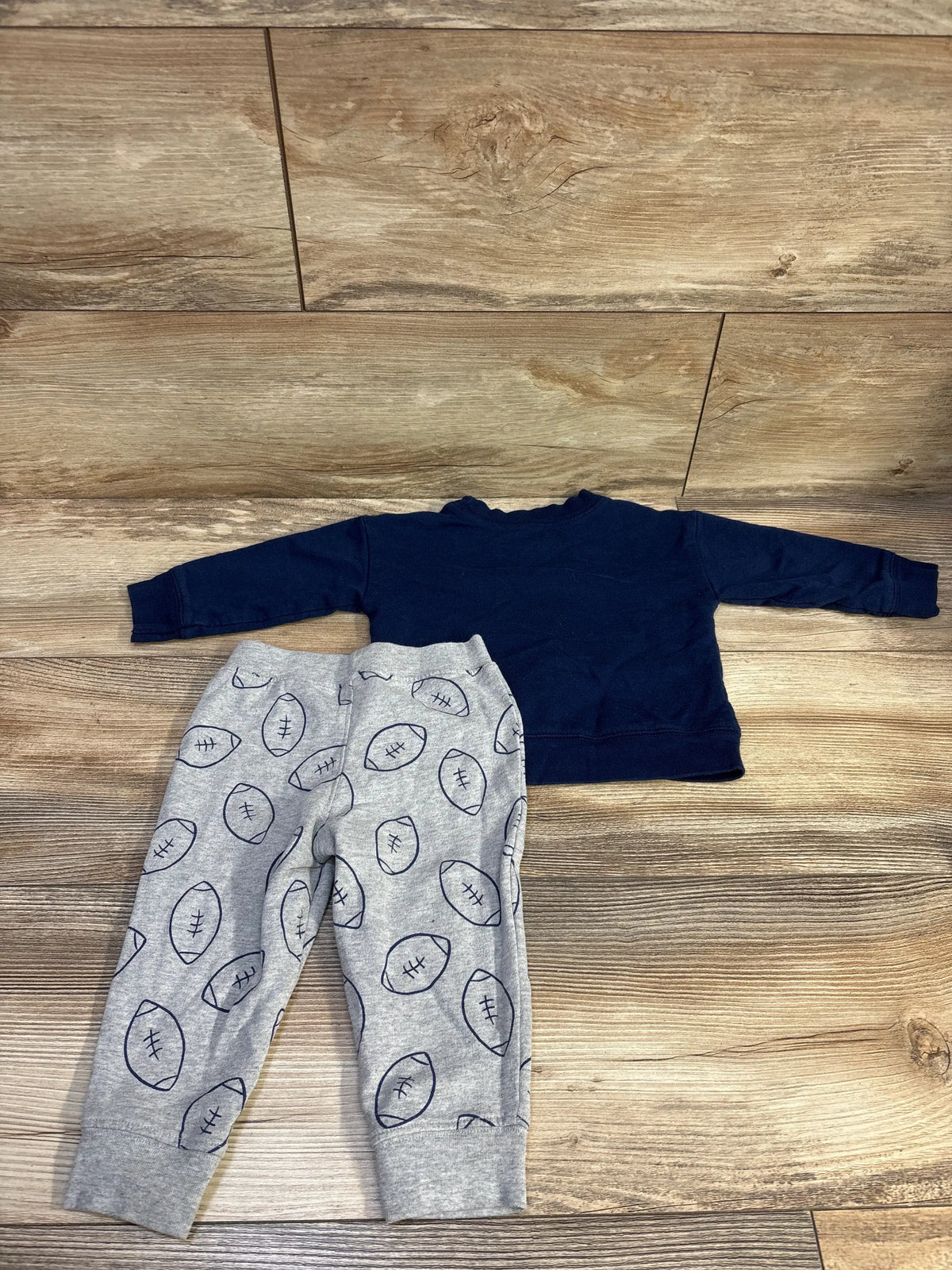 Top-down view of Just One You 2pc football sweatshirt and pants set with navy sweatshirt and gray football-print pants