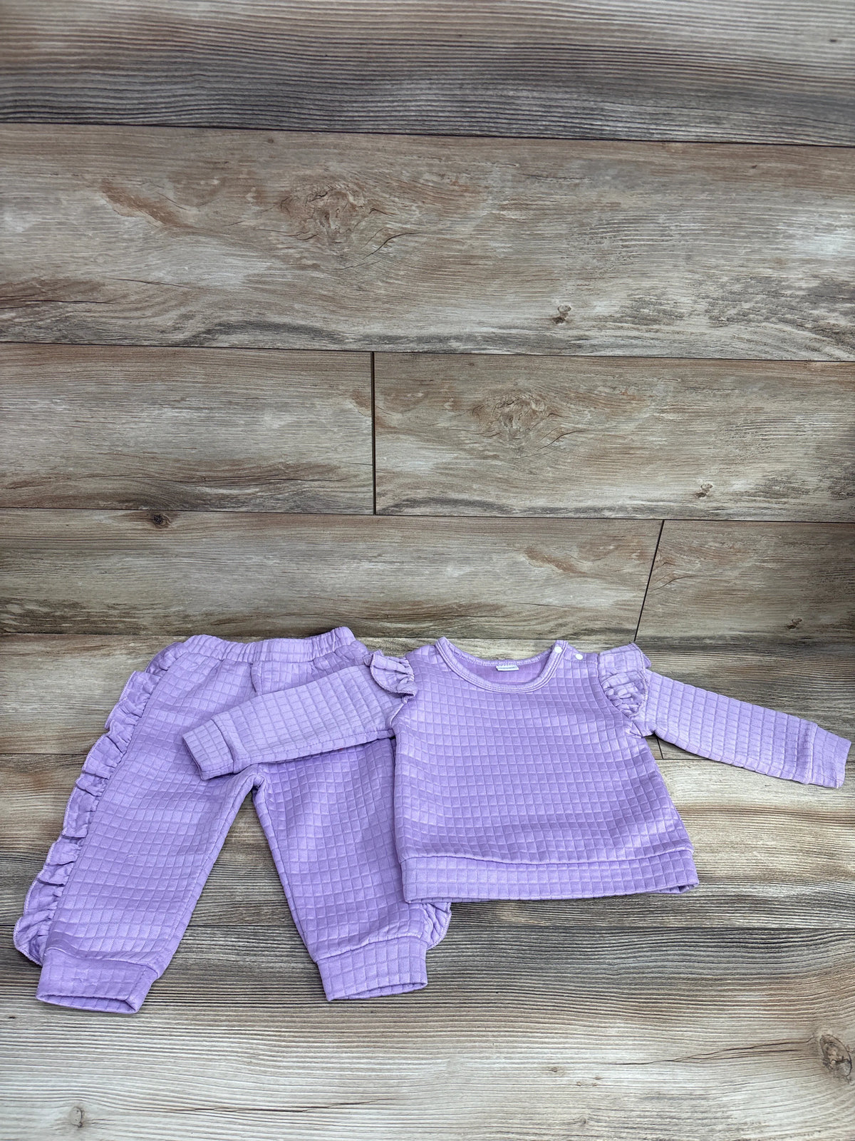 BeMeYourBBs 2pc purple ruffle sweatshirt and joggers set for babies on a wood background