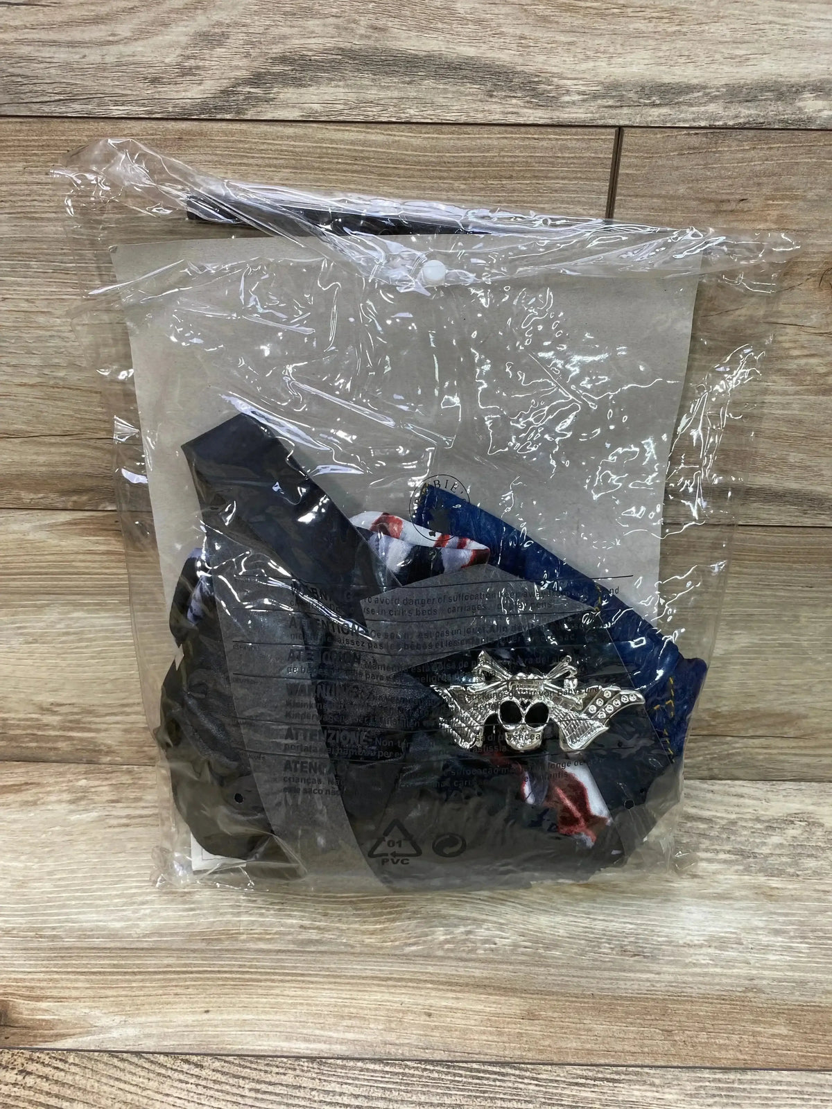 Front view of Rubies Rocked Out Zombie Girl Costume showcasing the dark costume and skull accessory in clear packaging