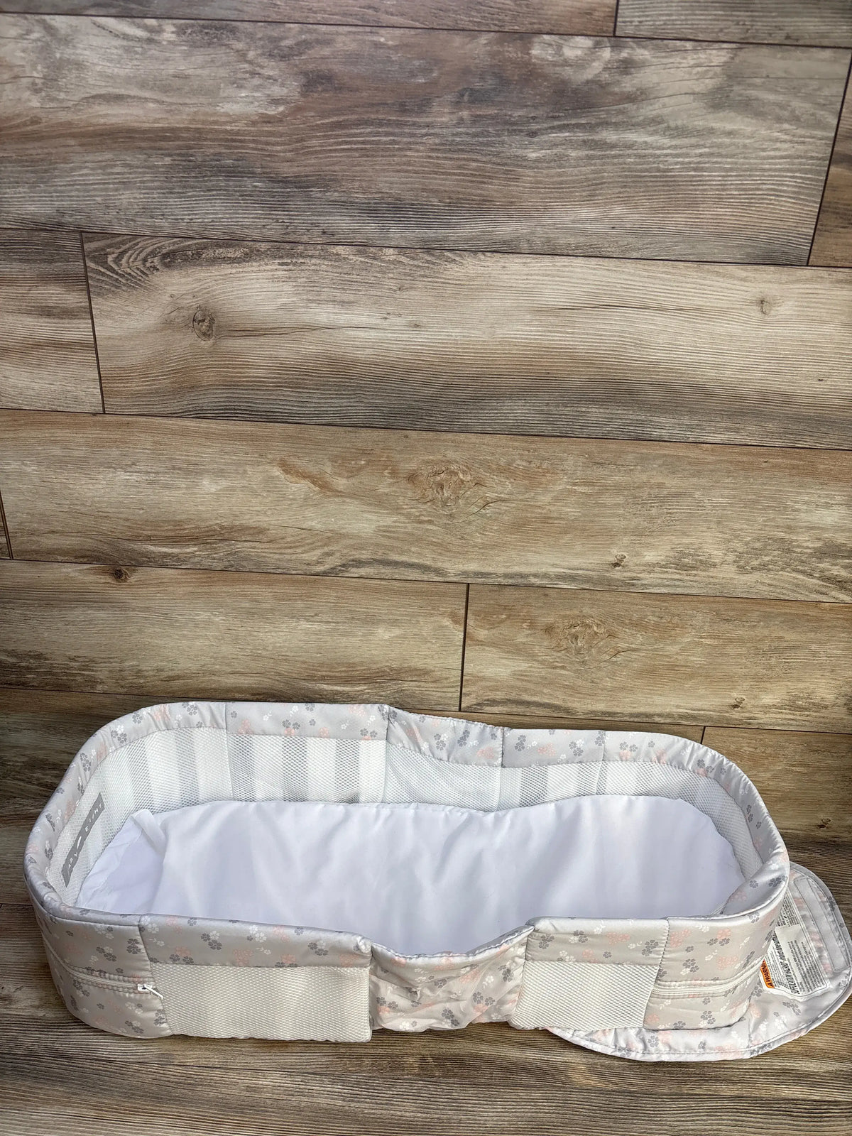 Top view of Baby Delight Snuggle Nest Harmony Portable Infant Lounger with floral fabric and mesh walls