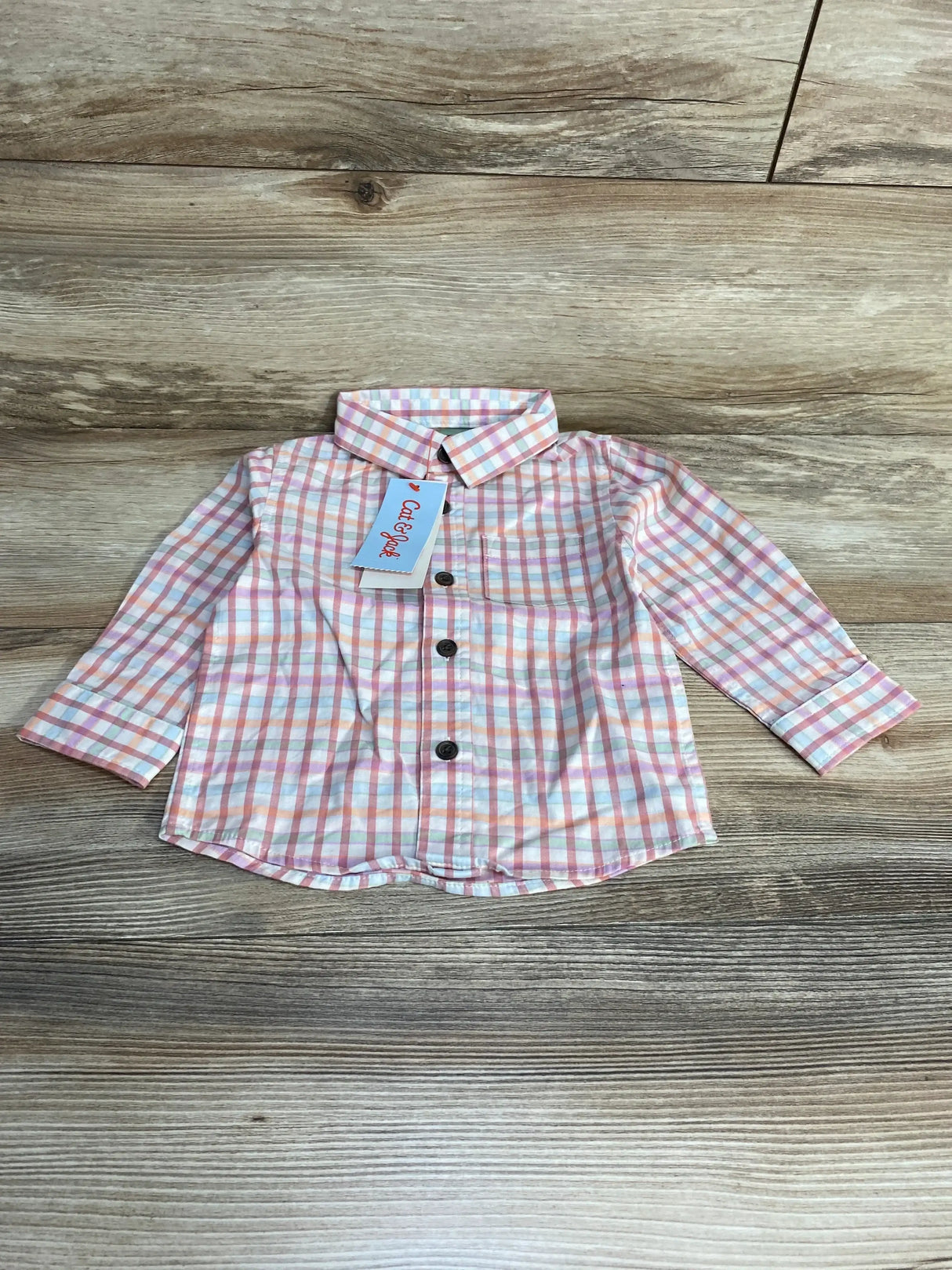 Front view of NEW Cat and Jack Plaid Button-Up Shirt in pink showcasing pastel plaid long sleeves chest pocket and hangtag on wood plank floor