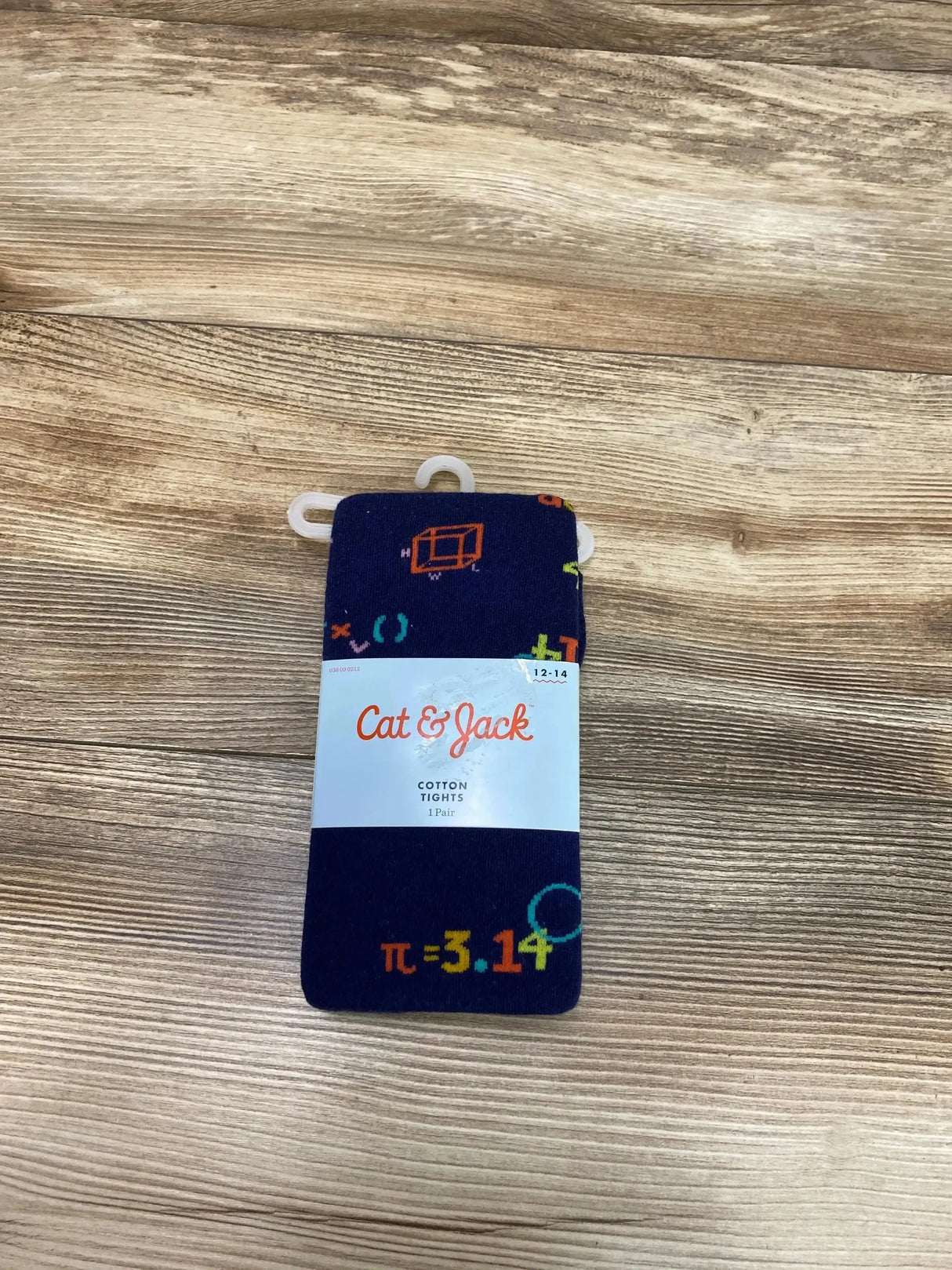 Flat lay of navy Cat & Jack cotton tights in packaging showing multicolored math-symbol print and size 12-14 on wood surface