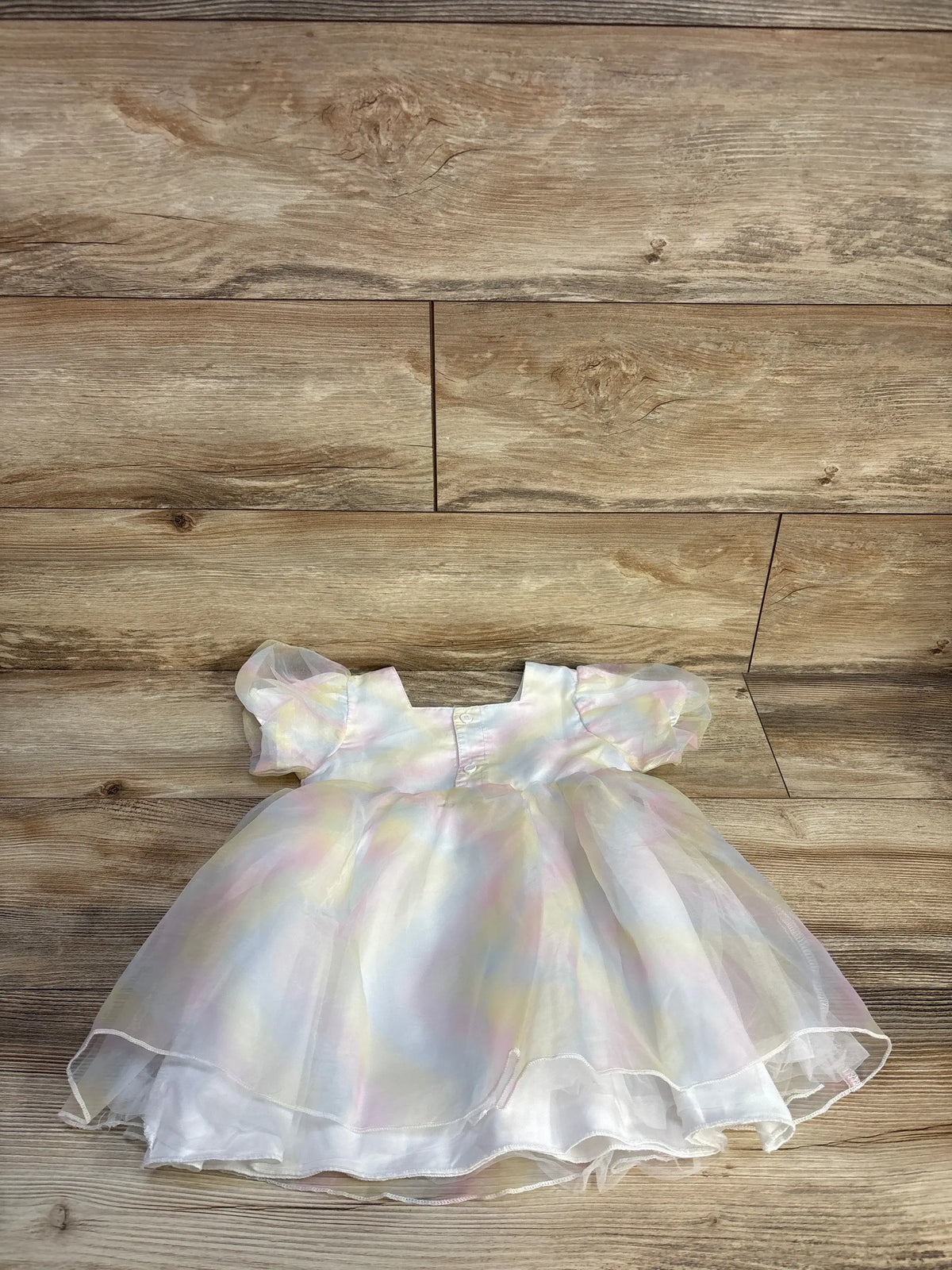 Front view of Shein rainbow tulle dress in white showcasing layered rainbow tulle detailing on a wood floor