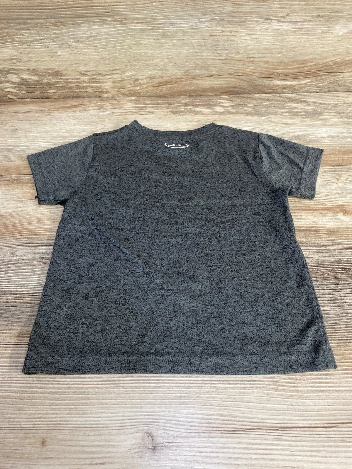 Front view of Under Armour Shot Blocker Shirt Grey sz 2T showcasing short sleeves and chest logo on a wood background