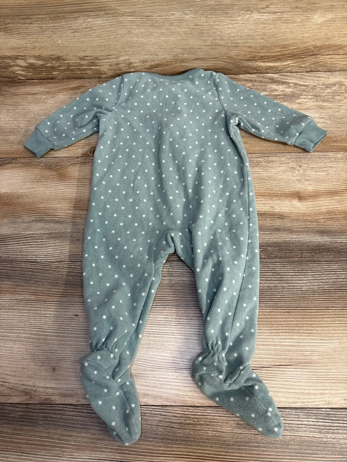 Back view of Carter’s green polka-dot footed sleeper, size 3-6M, showing long sleeves and built-in feet on wood background