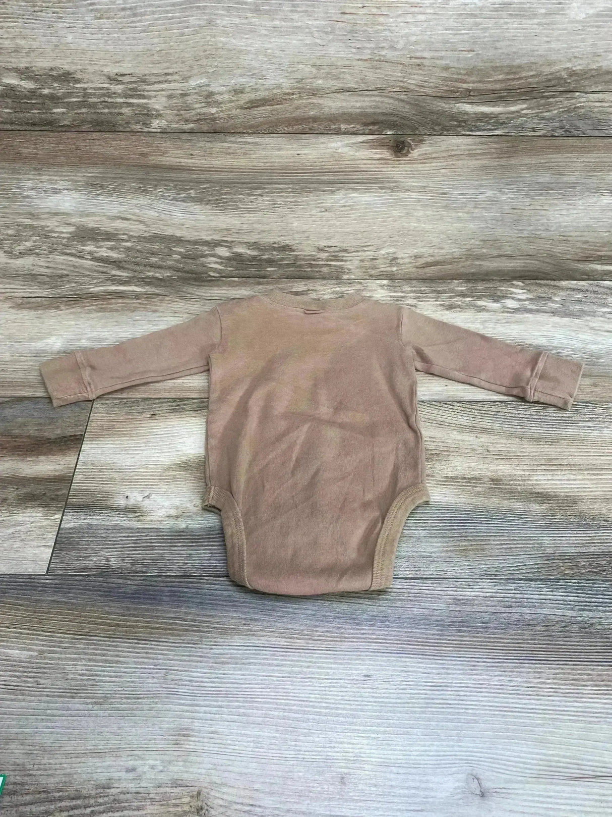 Back view of Little Pilgrim Nap Time Sloth bodysuit in brown showcasing long sleeves and crew neck on wood floor background