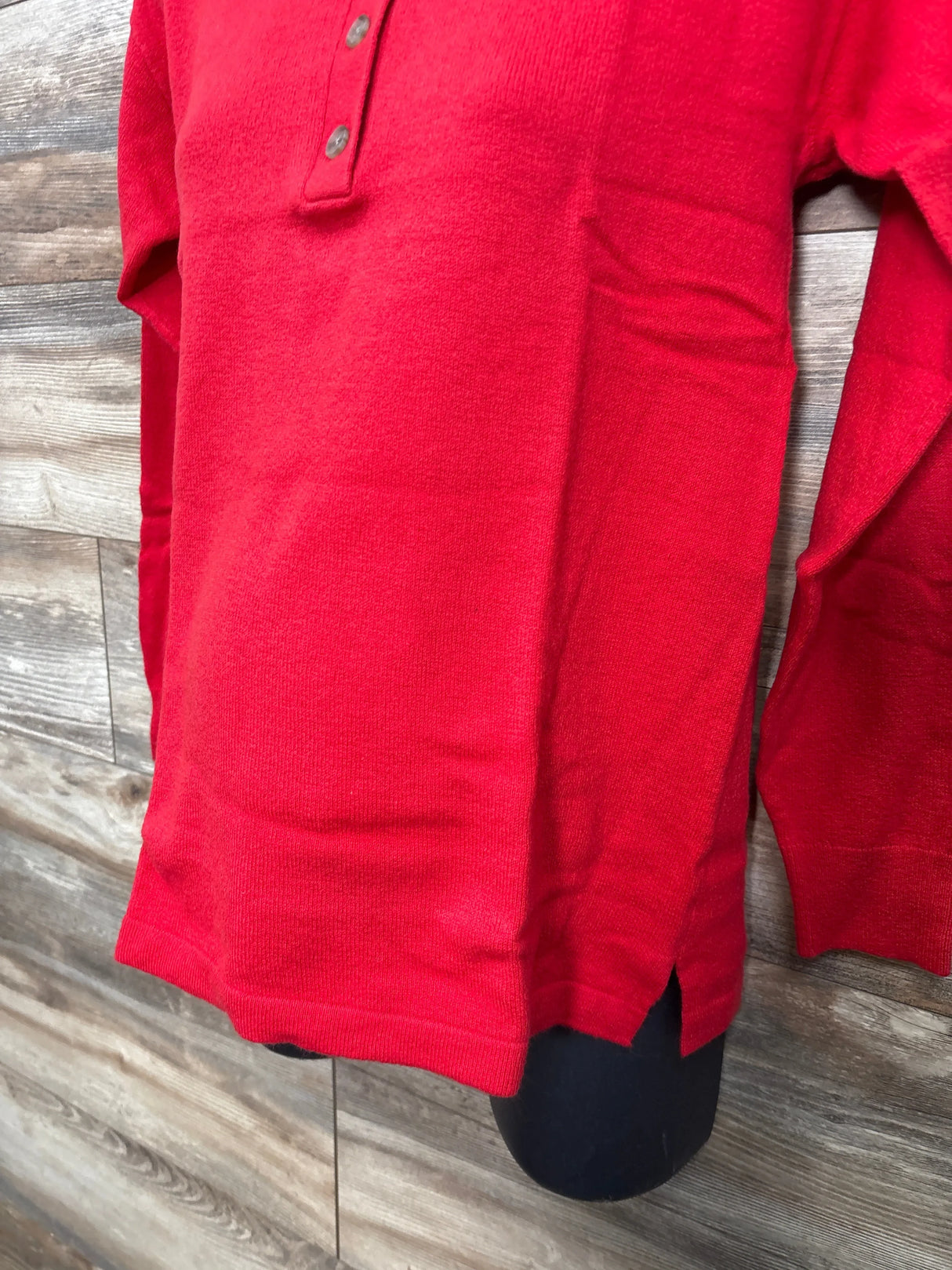 Red knit long sleeve children's shirt with button placket displayed on mannequin