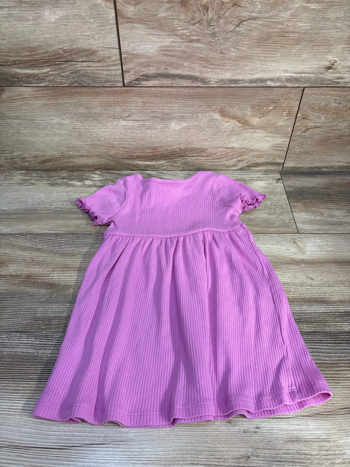 Front view of Cat & Jack sage ribbed dress in size 2T showcasing short ruffled sleeves and gathered skirt on wood-look flooring