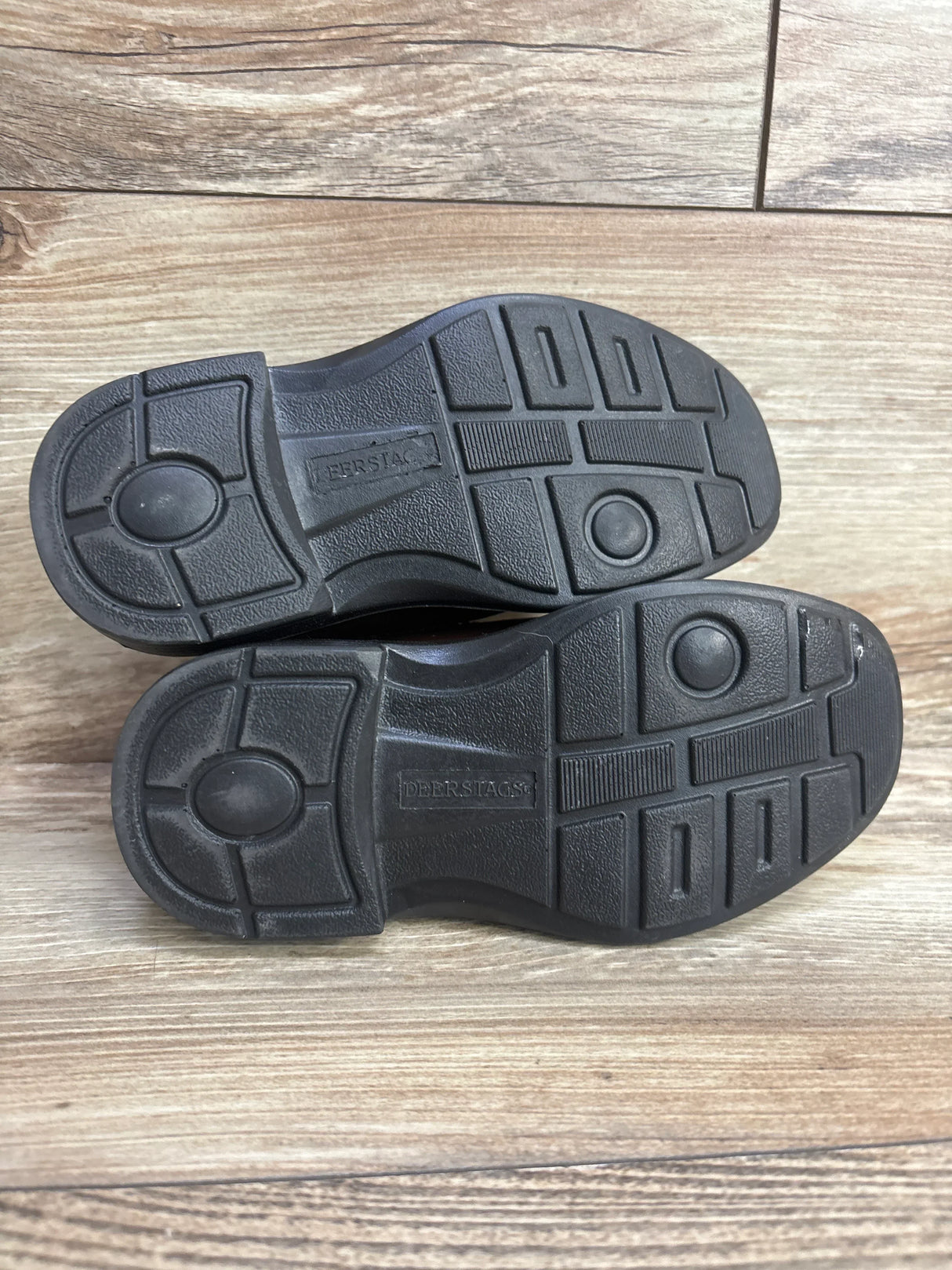 Black Deer Stags shoe soles on wood floor, showing tread pattern and brand name