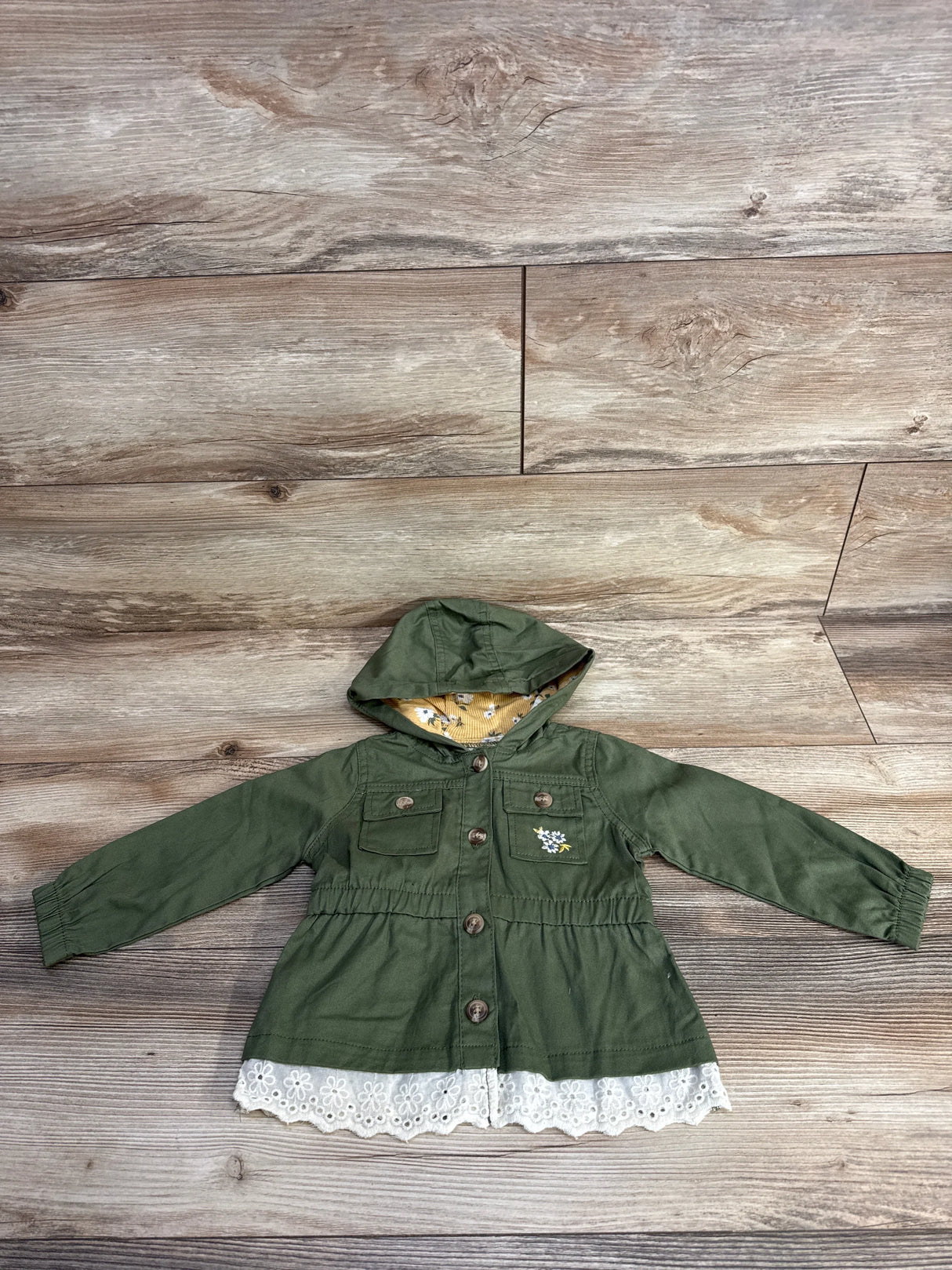 Olive green toddler hooded jacket with floral embroidery and lace trim on wood floor