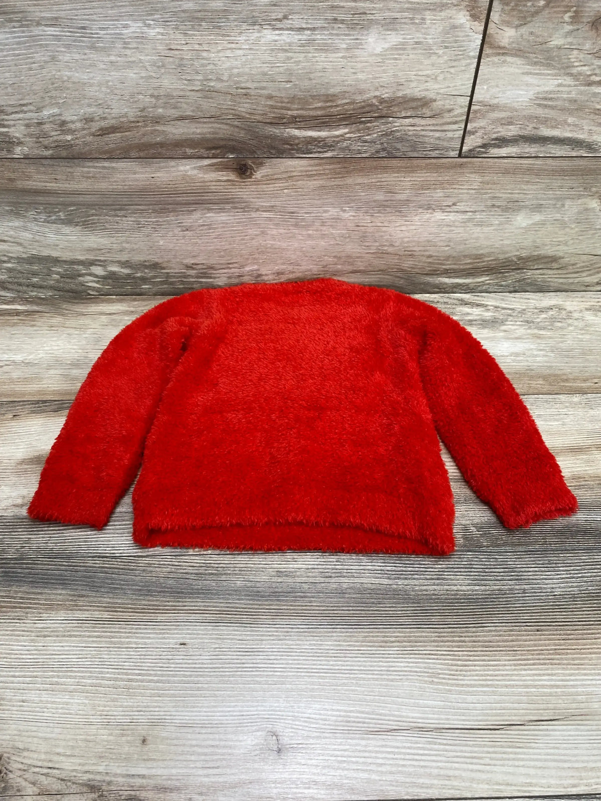 Flat-lay of Harper Canyon Fluffy Intarsia toddler sweater in red, size 24 months, showcasing plush fuzzy texture on light wood background