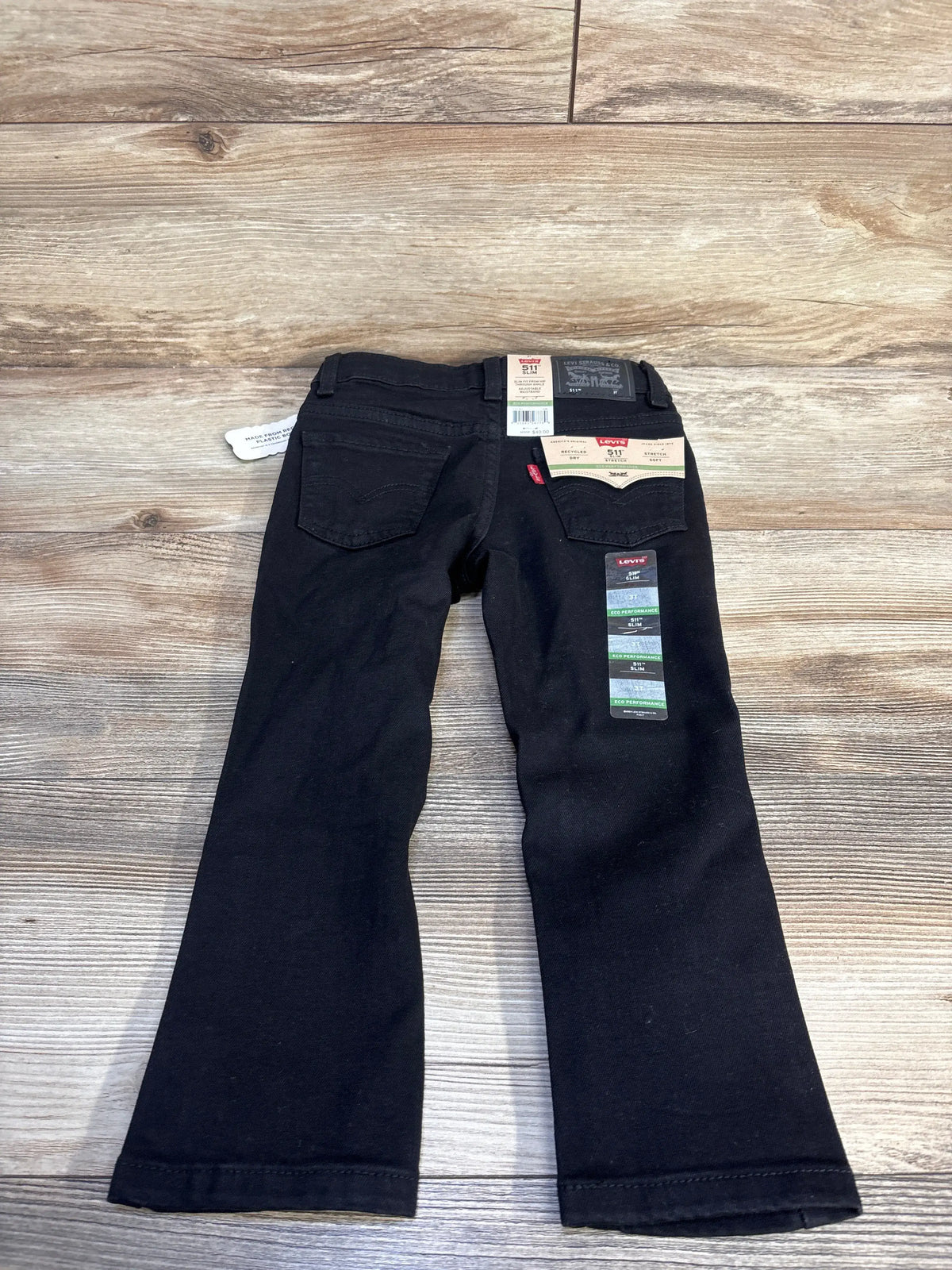 New black Levi's 511 slim fit jeans for toddlers size 3T on a wooden background.