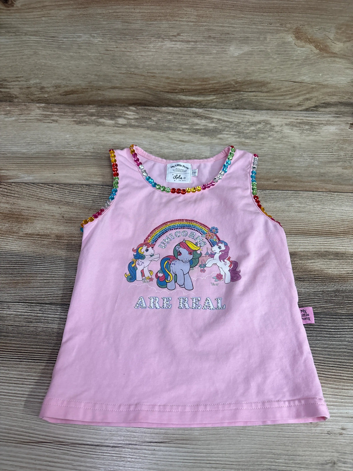 Front view of pink My Little Pony tank top, size 2T, with rainbow sequin trim and Unicorns Are Real graphic on wood