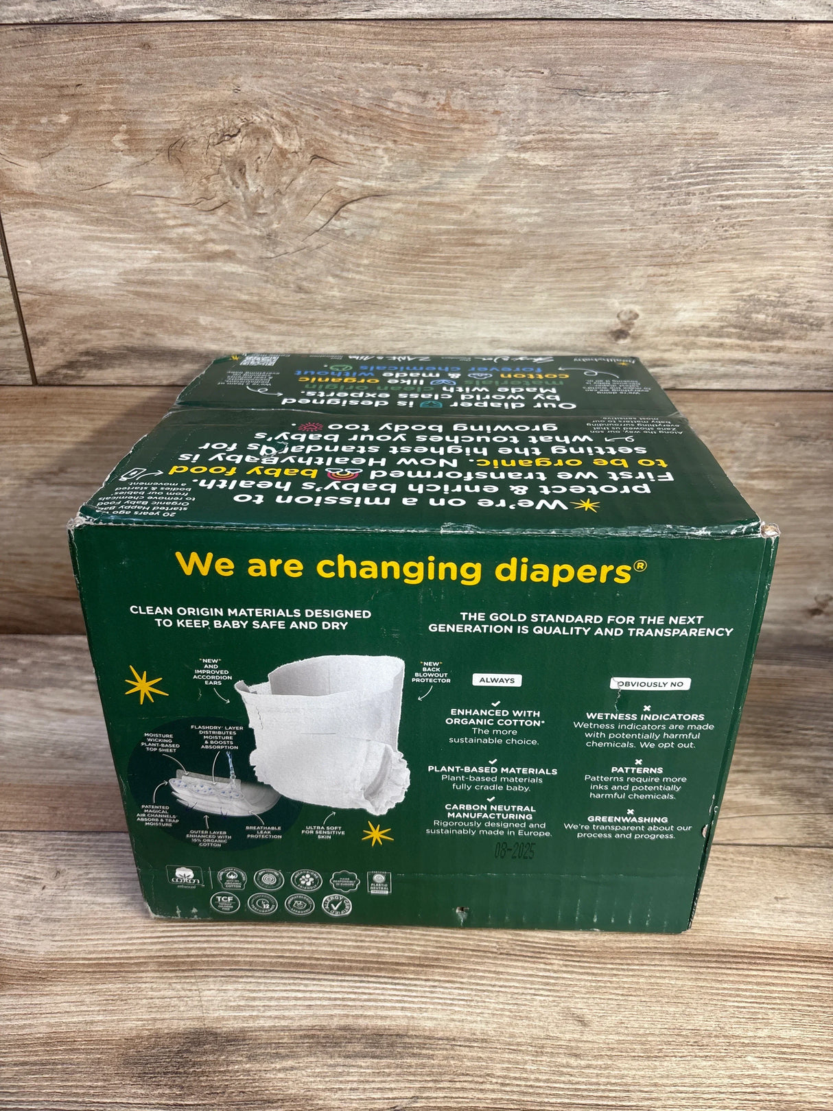 Front view of HealhtyBaby 56 ct size 3 diaper box showing the We are changing diapers headline on a wood background