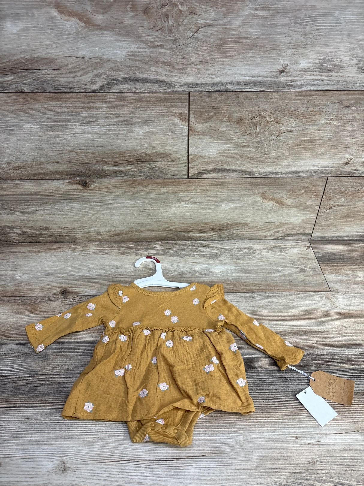 Mustard yellow long sleeve baby dress with small white floral print and attached bodysuit