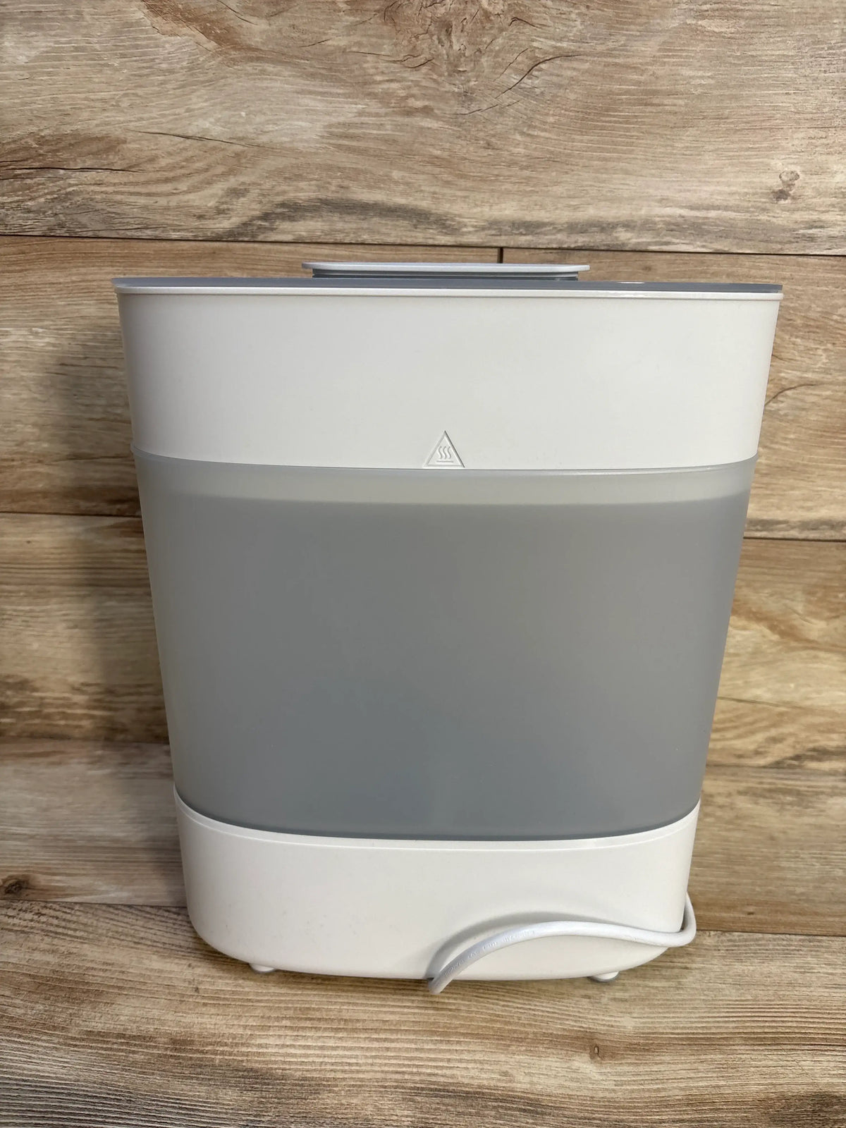 Front view of Philips Avent Advanced Electric Steam Sterilizer showcasing its white and gray design with a wood-grain background