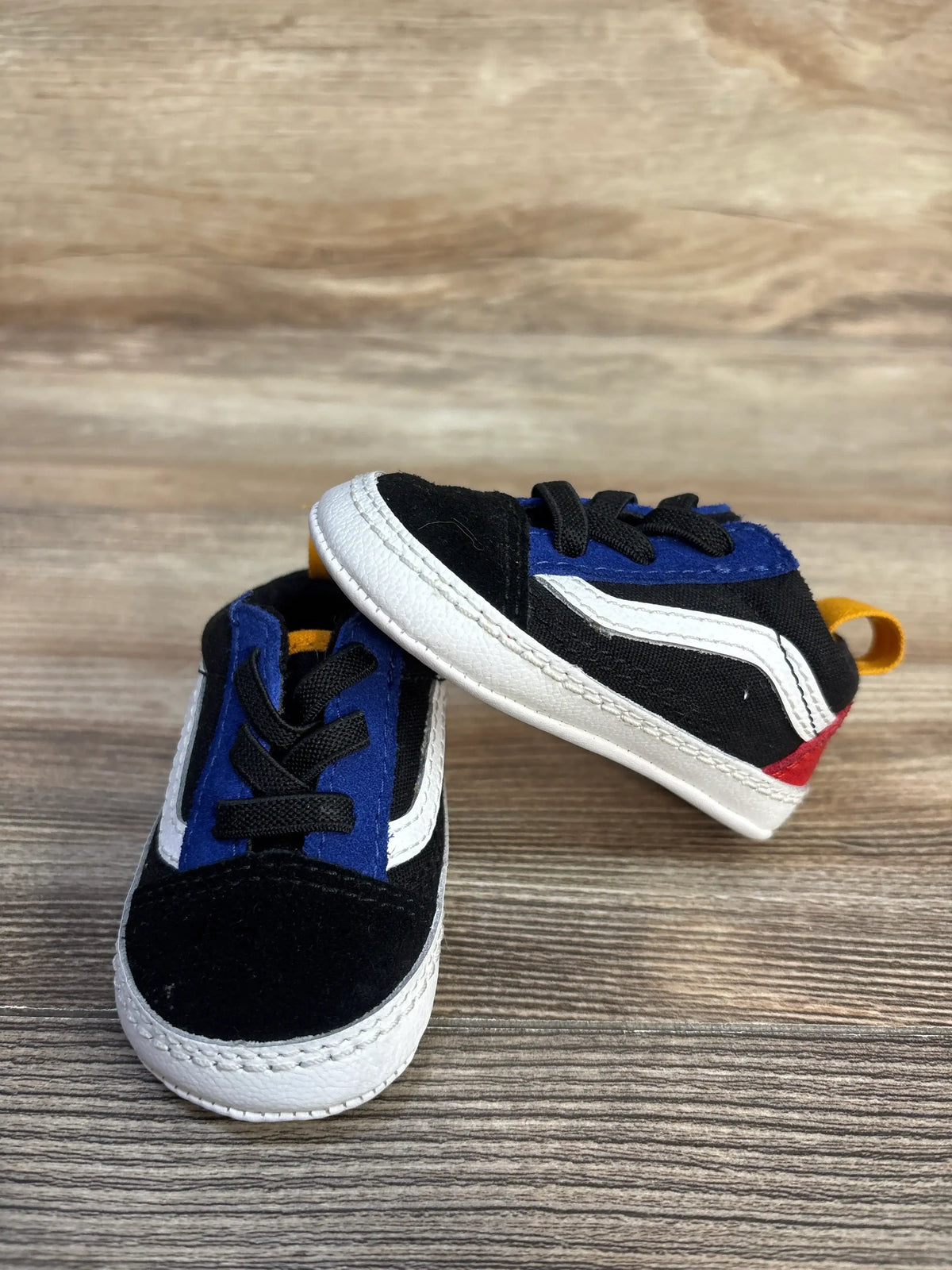 Angled view of black Vans Old Skool Crib Shoes, size 2C, with canvas and suede uppers, white side stripes, and heel tabs