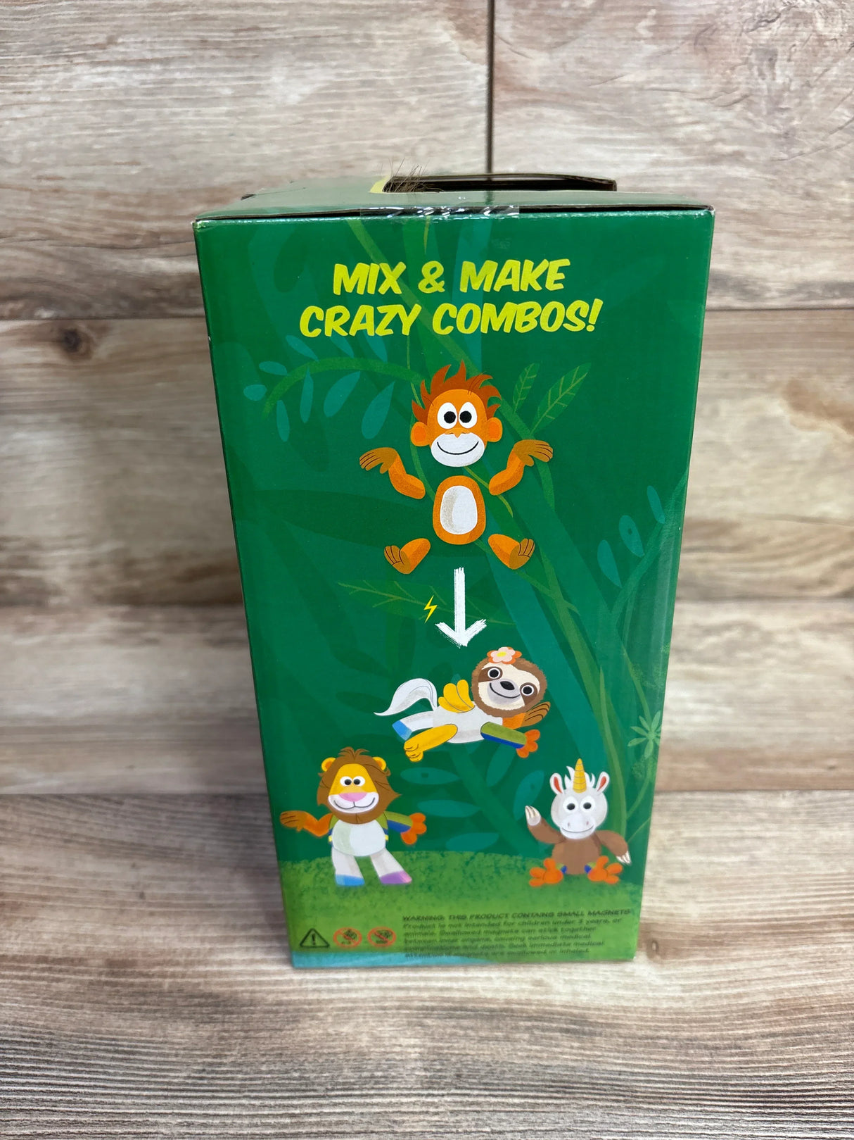 Side view of Animoodles Brady Lion green box panel showing Mix and Make Crazy Combos cartoon animals on wood floor