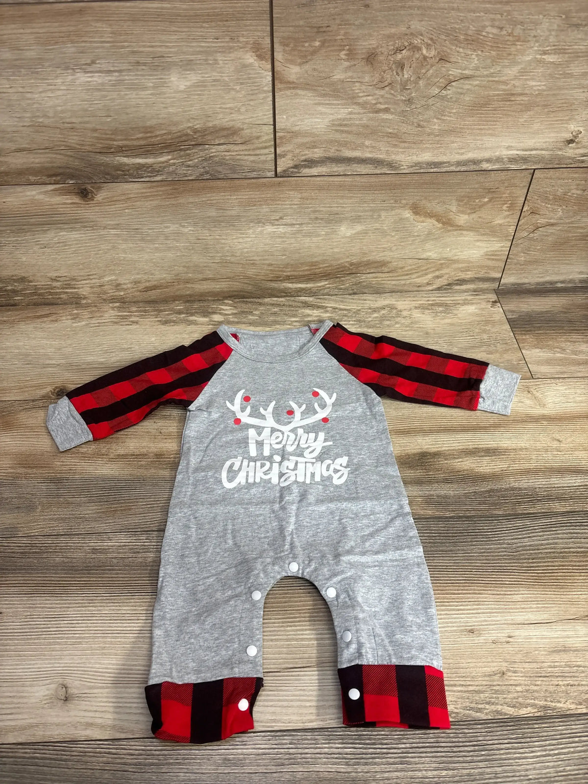 Gray baby onesie with red plaid sleeves, reindeer antlers, and 'Merry Christmas' print for holiday wear.