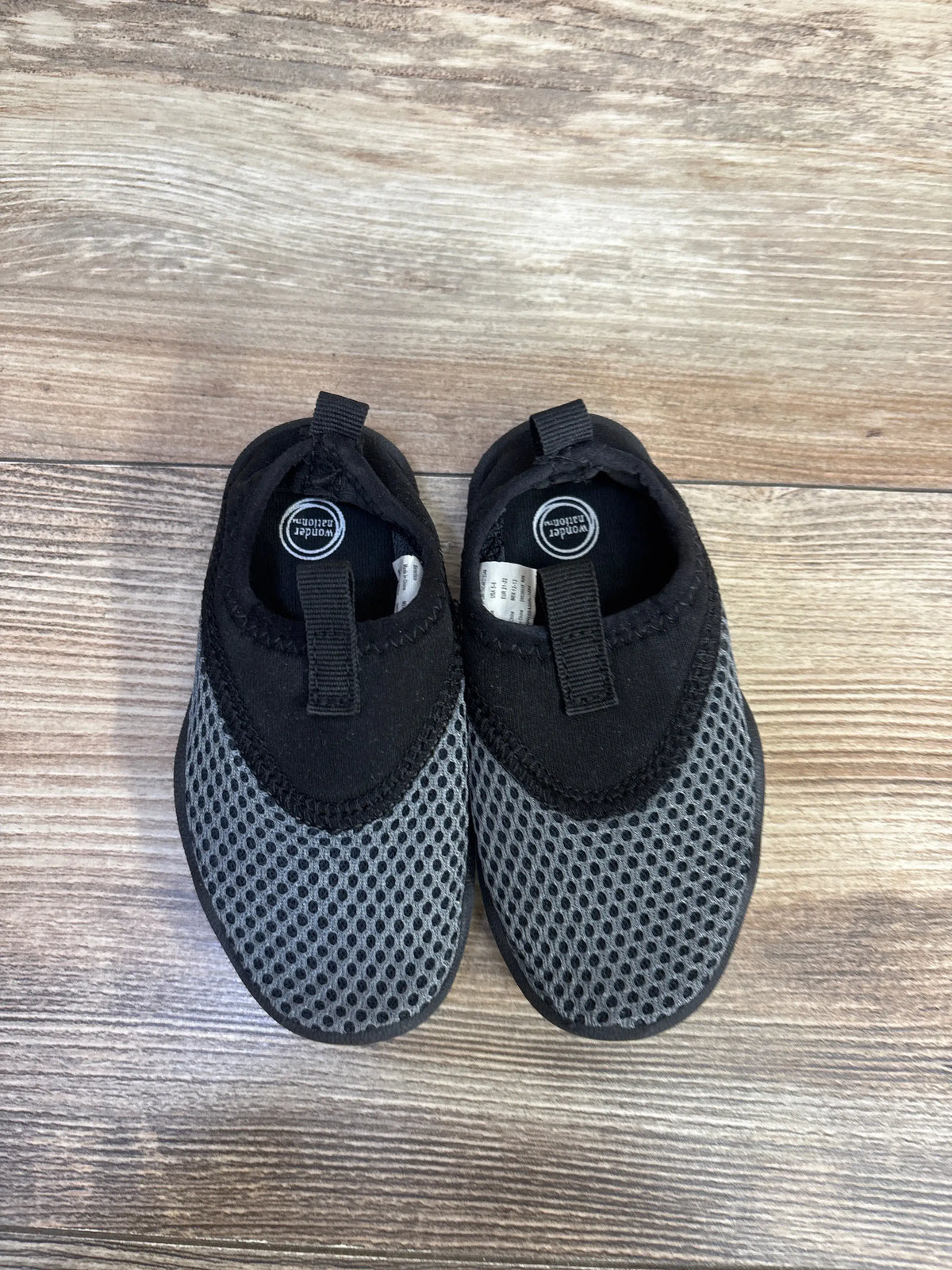 Pair of grey and black Wonder Nation aqua sock water shoes for kids on a wooden surface.