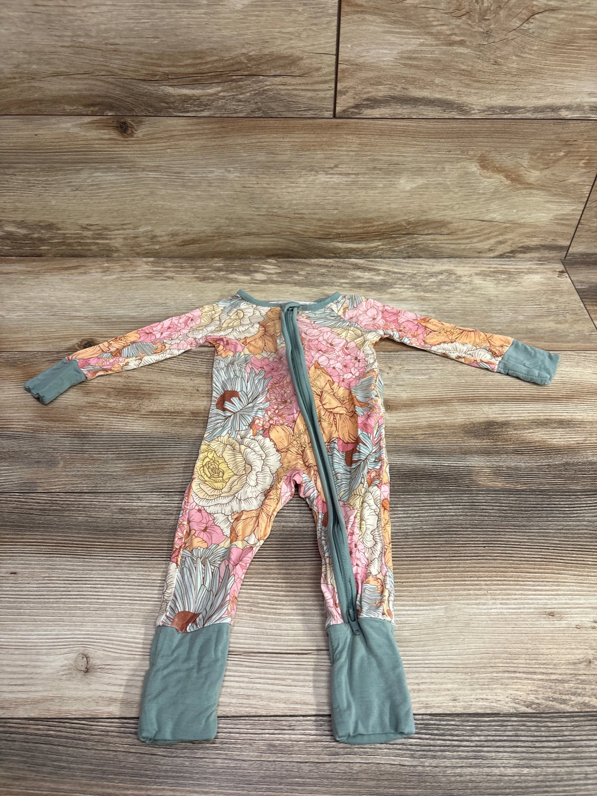 Front view of Miozing vintage floral bamboo convertible sleeper in green showcasing full length zipper with wood background