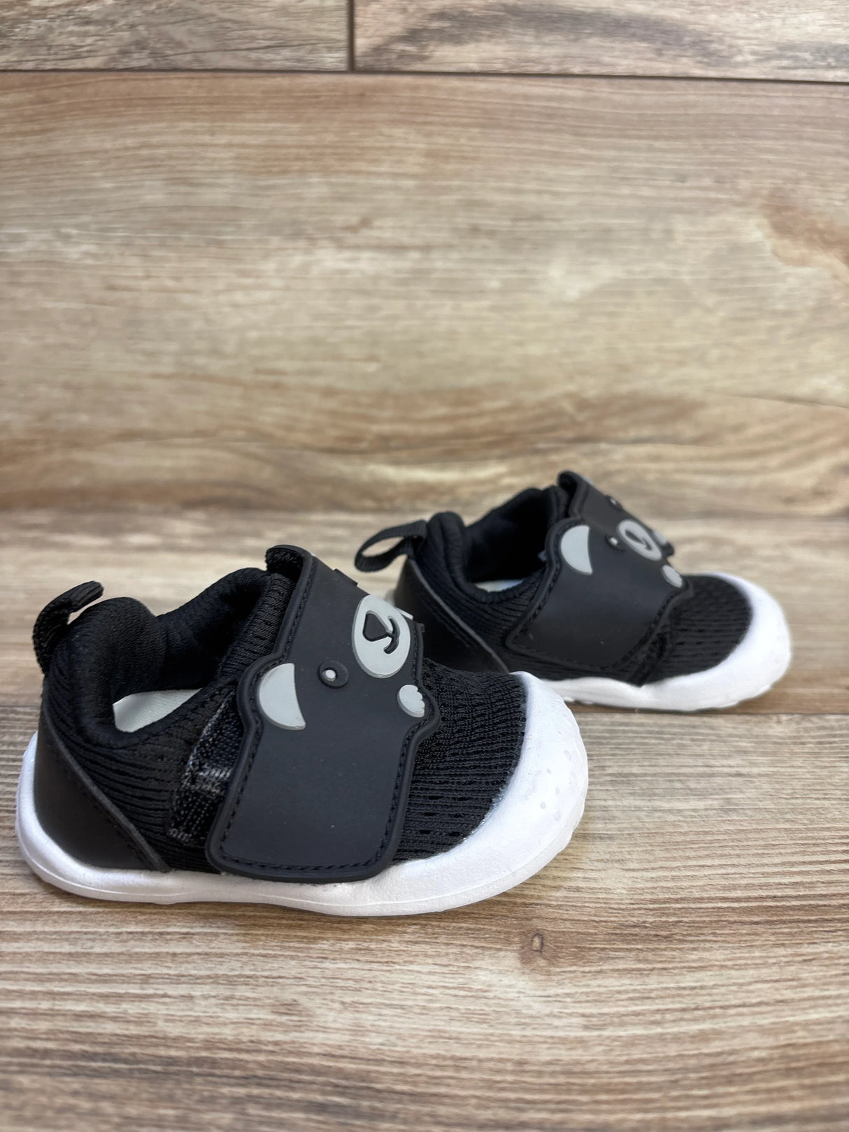 Black baby sneakers with white soles and cute bear face design, perfect for toddlers and first walkers.