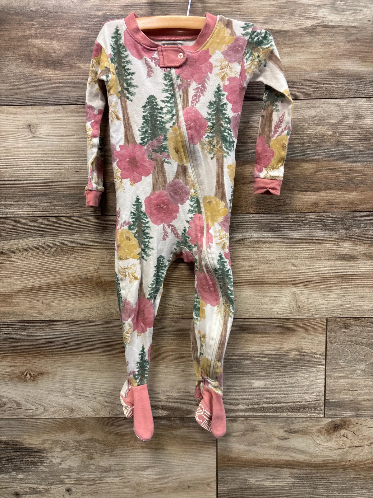 Front view of Burt’s Bees Baby 18-month floral sleeper showcasing a pink floral print, front zipper, and built-in feet on wood flooring