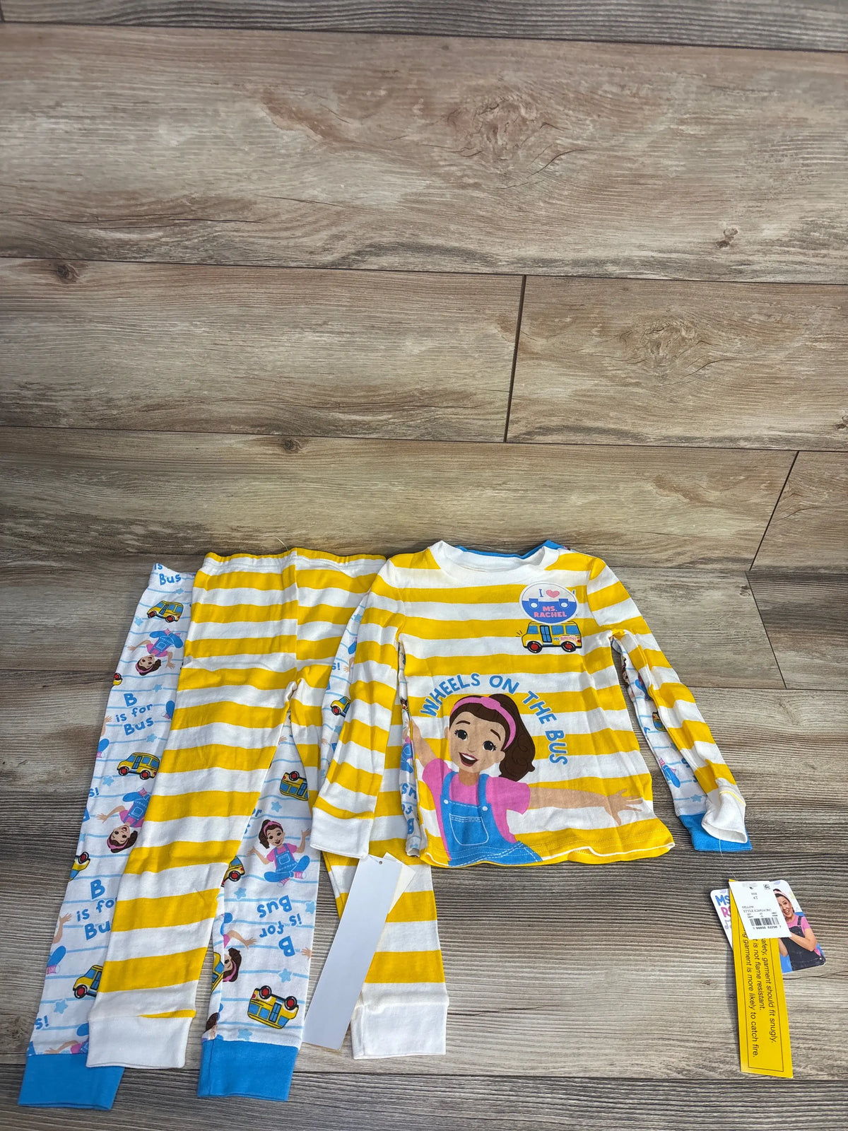 Front view of Ms Rachel four-piece snug fit pajama set showcasing two tees and two PJ pants on a wood floor