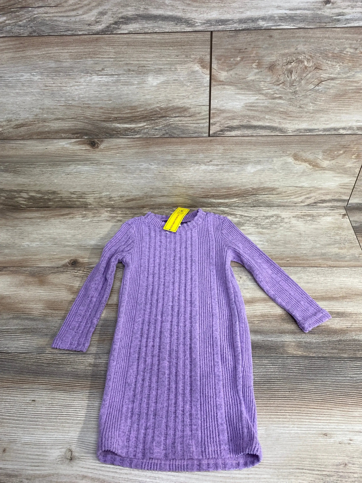 Long sleeve purple ribbed knit girls dress on wood background