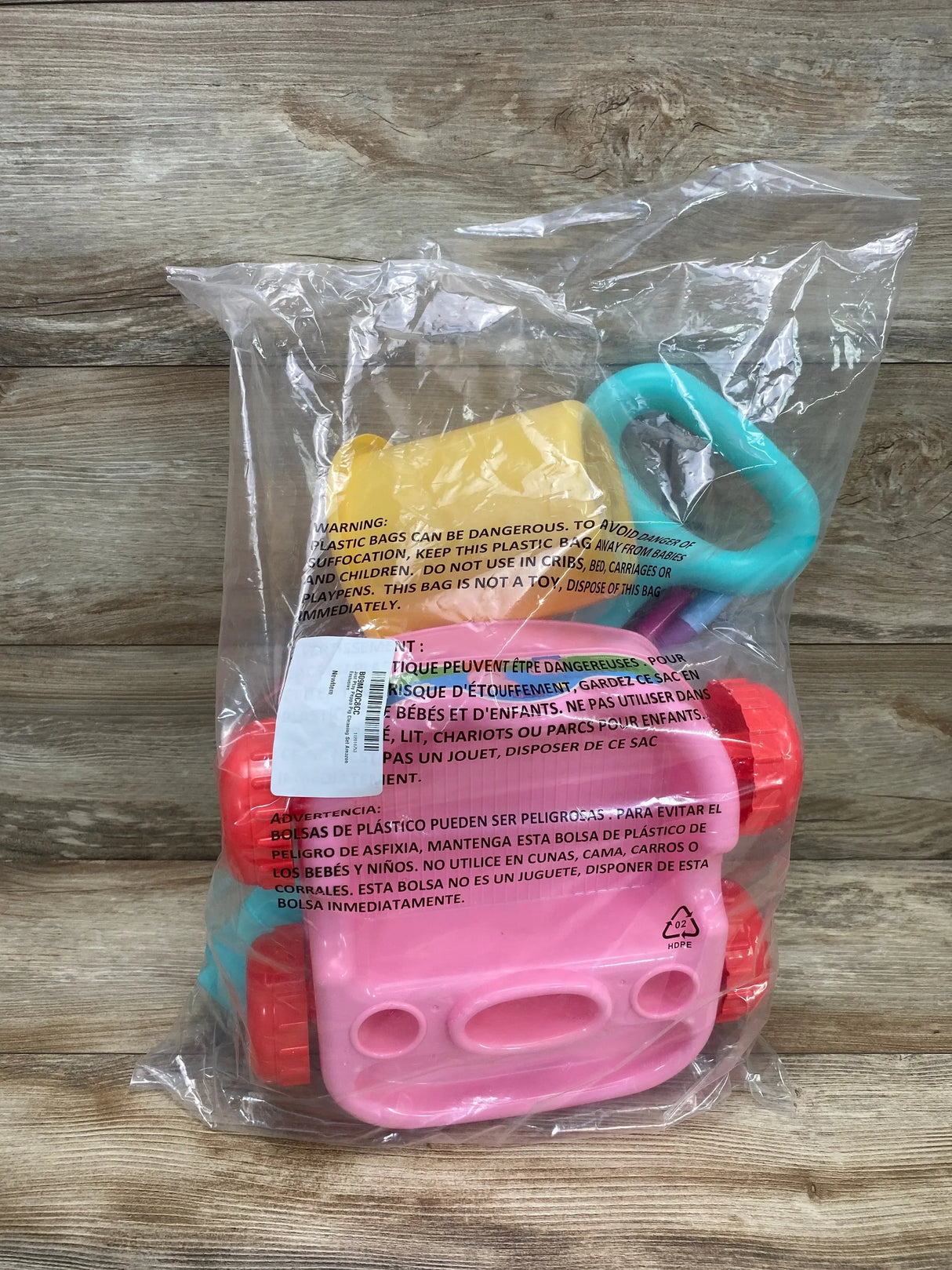 Front view of Peppa Pig cleaning trolley set: pink trolley with turquoise handle and yellow bucket sealed in clear bag