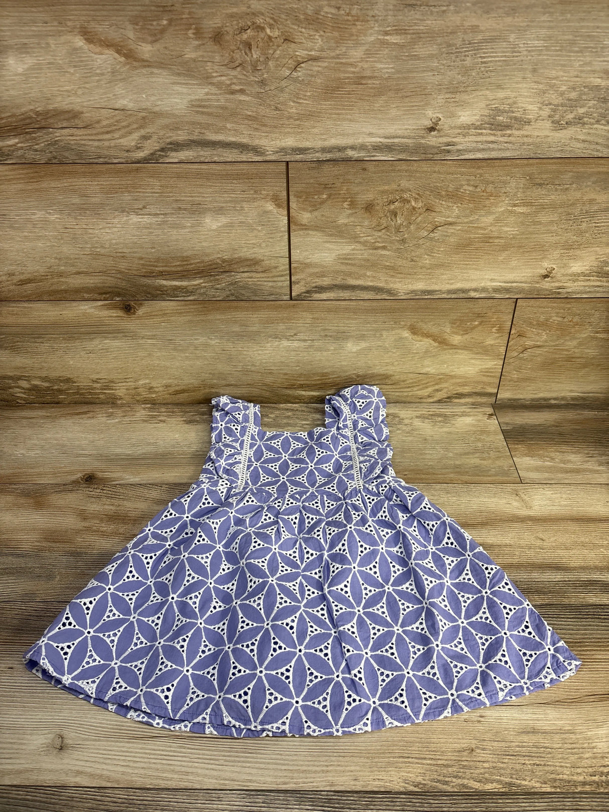 Front flat-lay of Janie & Jack purple eyelet petal toddler dress (3T) showing ruffled shoulder straps and circular eyelet pattern on wood floor
