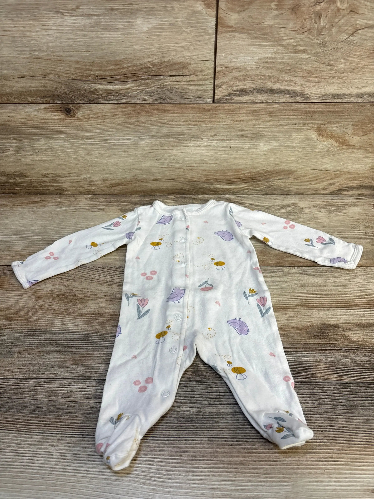 Flat lay of Carter’s Ivory bird-print sleeper (3M) showcasing all-over bird and floral print on wooden floor