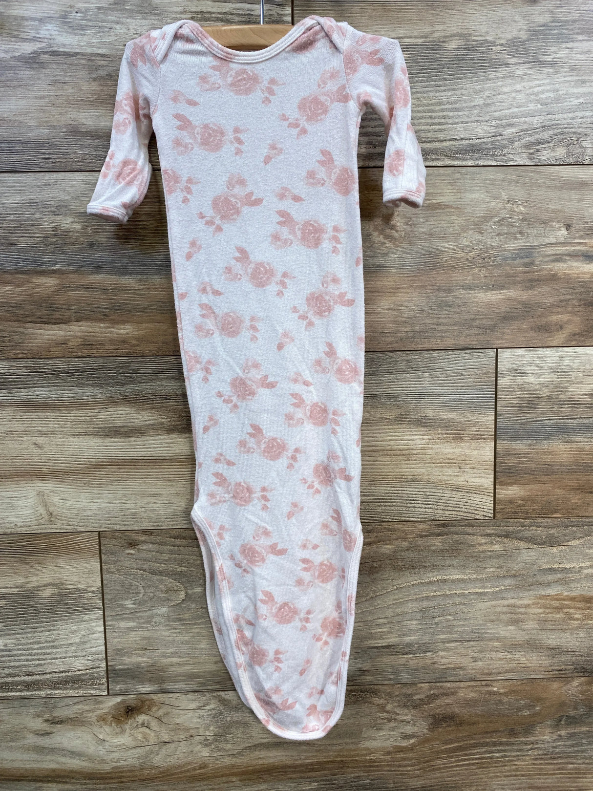 Front view of Aden + Anais newborn pink floral knot gown showing long sleeves and knotted bottom on wooden floor background