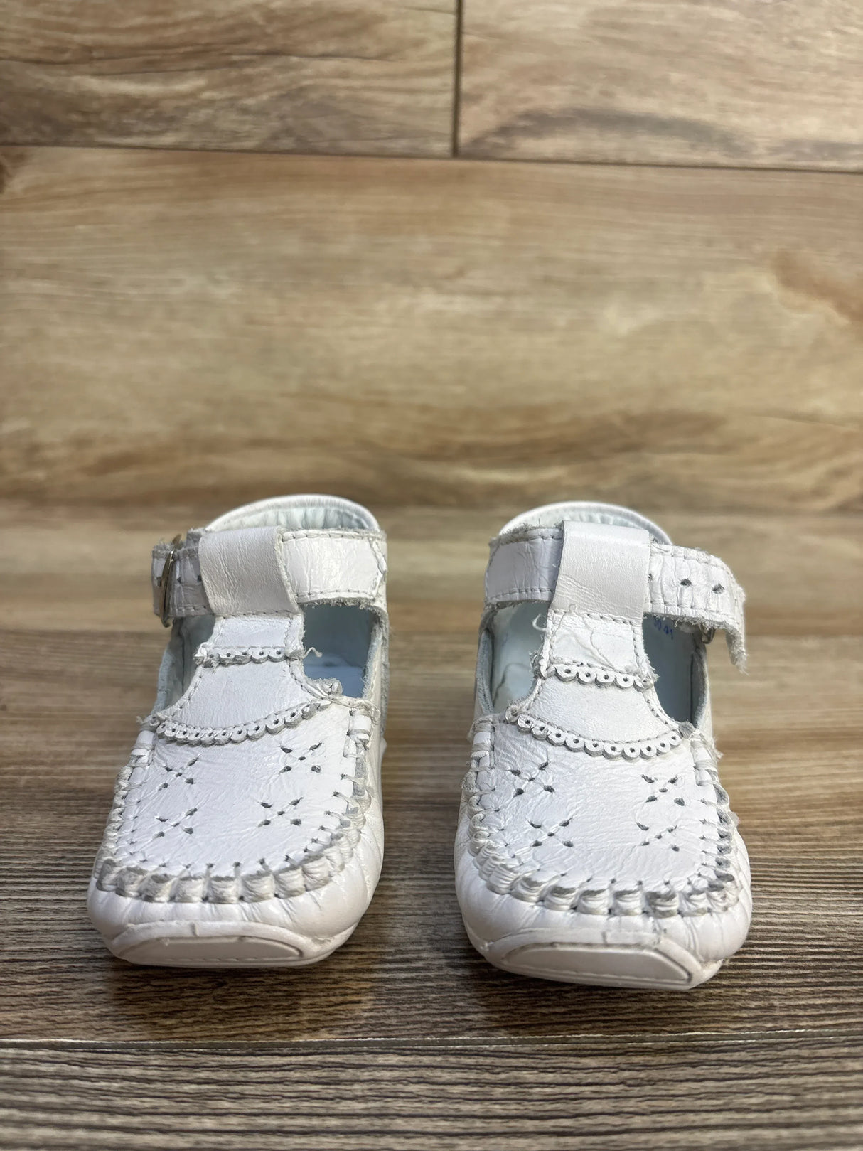 White baby Mary Jane shoes with scalloped trim and soft sole, perfect for infants and toddlers.