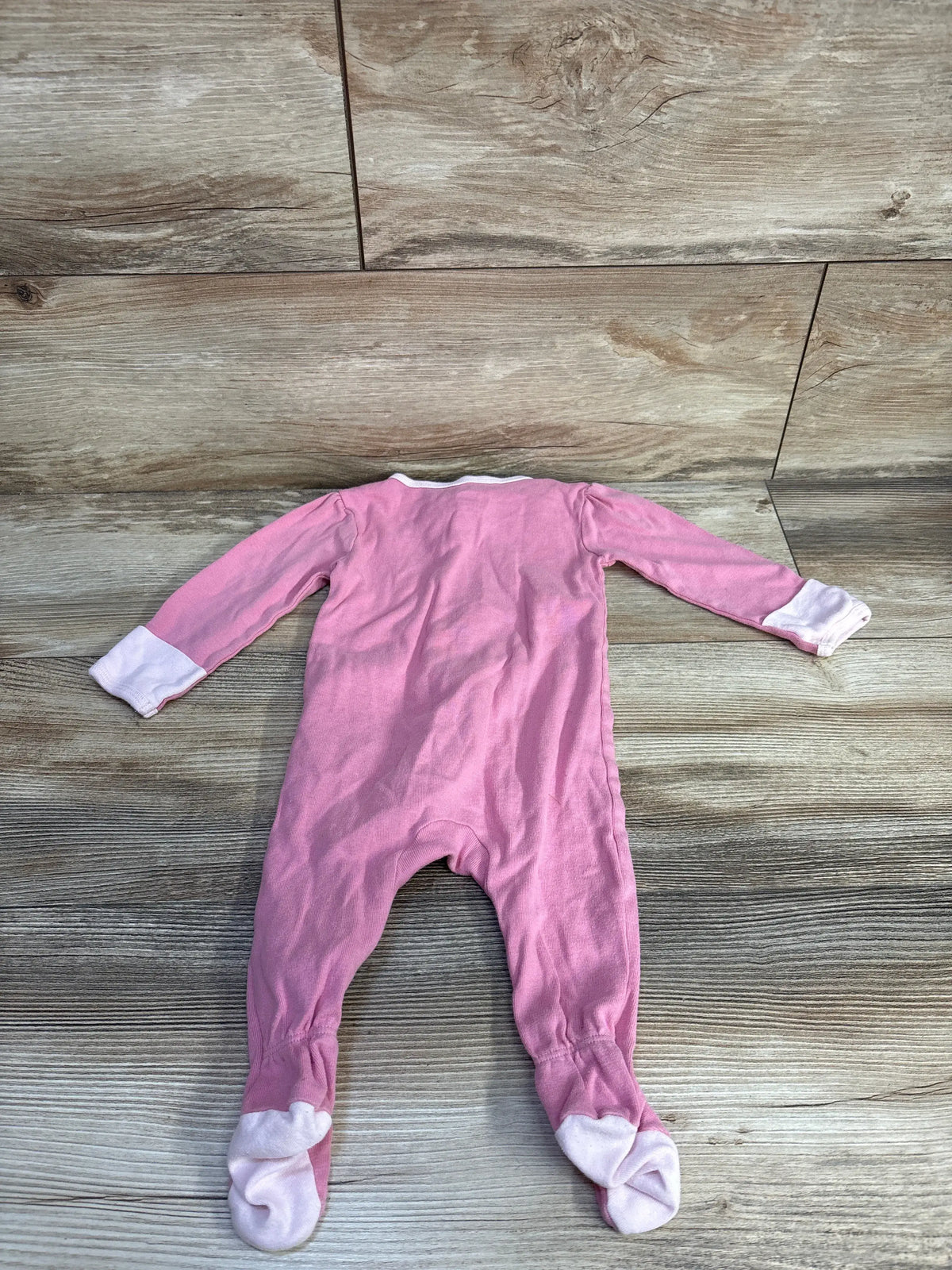 Front view of Cloud Island pink baby sleeper, size 3 to 6 months, with long sleeves and footed legs on wood flooring