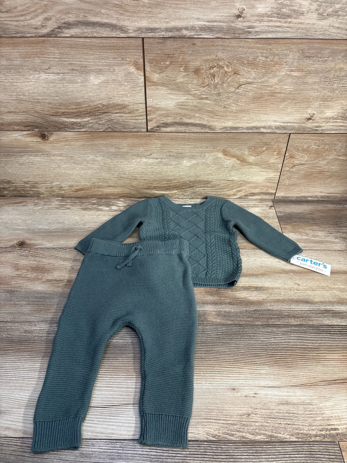 Overhead view of Carter’s green two-piece knit sweater and leggings set showcasing cable-knit detail and ribbed cuffs