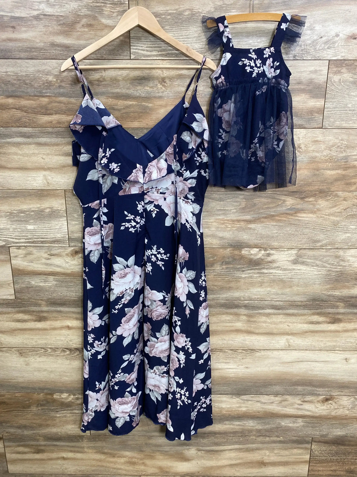 Front view of PopReal Mommy and Me Floral Dresses 2pk showcasing navy floral adult and child dresses on a wood floor