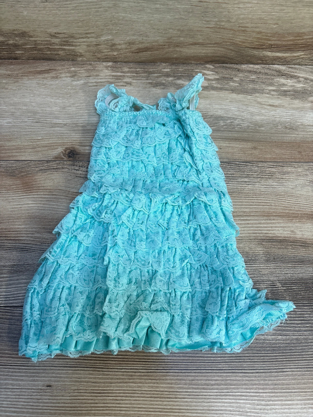 Aqua blue lace ruffle toddler dress on wood background, sleeveless, used kids clothing