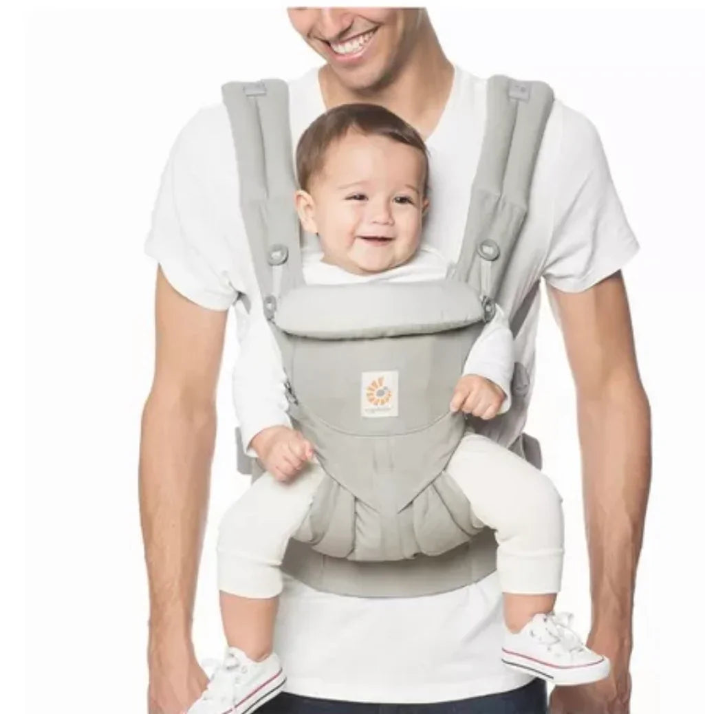 Dad wearing baby in ergonomic front carrier, gray color, child smiling