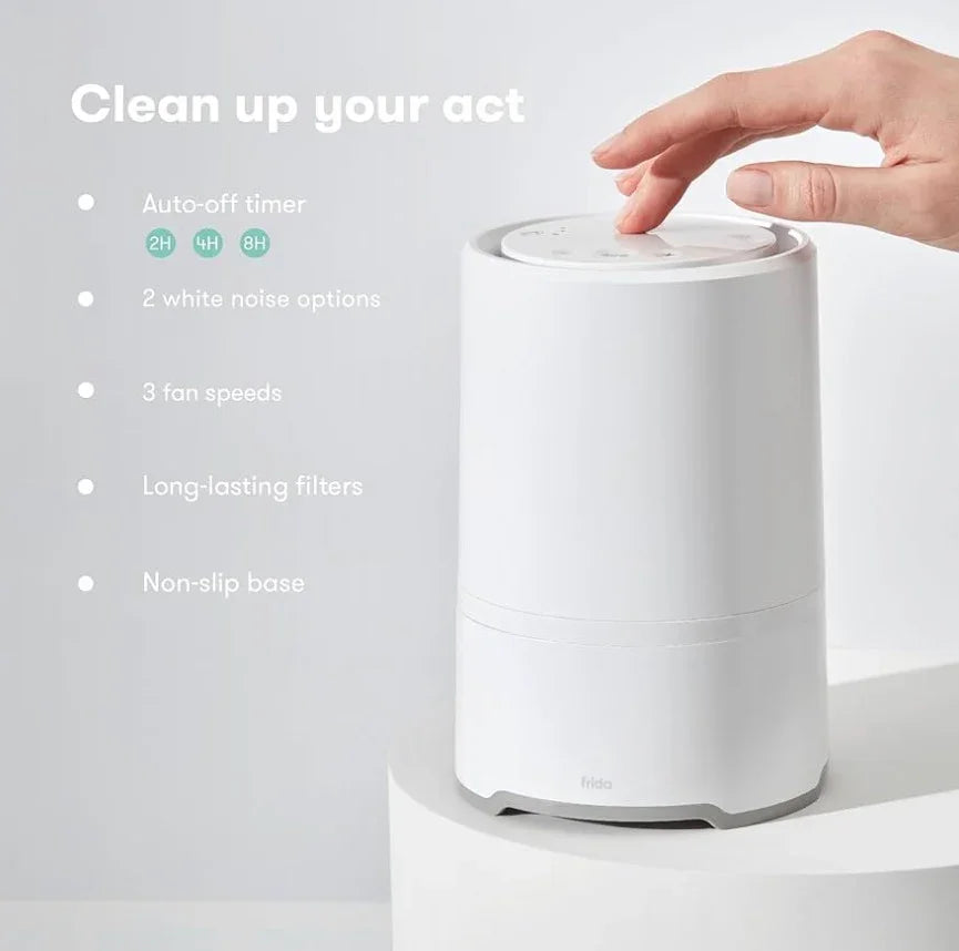 Angled view of Frida Baby 3-in-1 air purifier showing touch-top controls, non-slip base, and overlay 'Clean up your act'