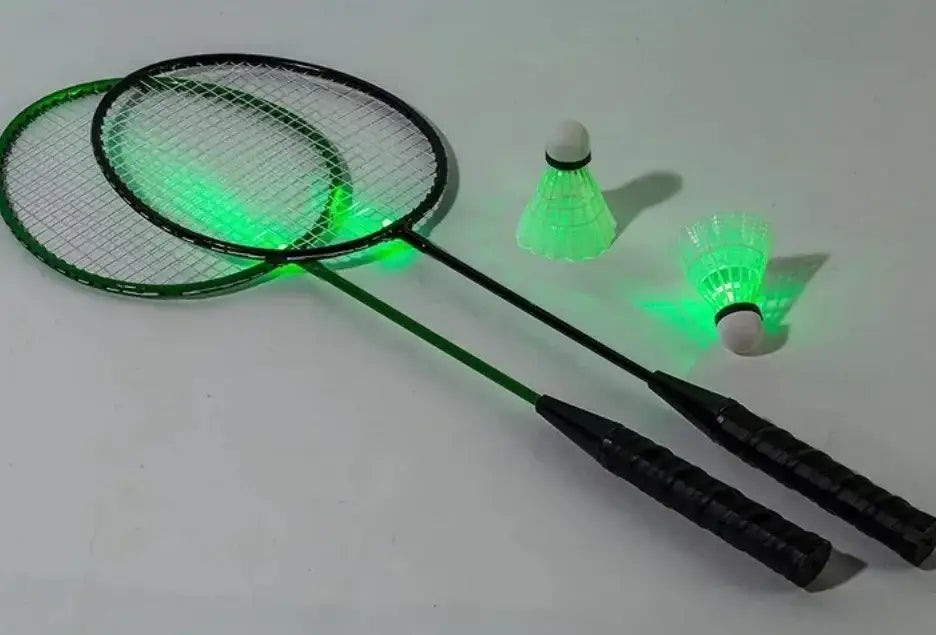 Two badminton rackets and two LED light-up shuttlecocks with green glow on white background