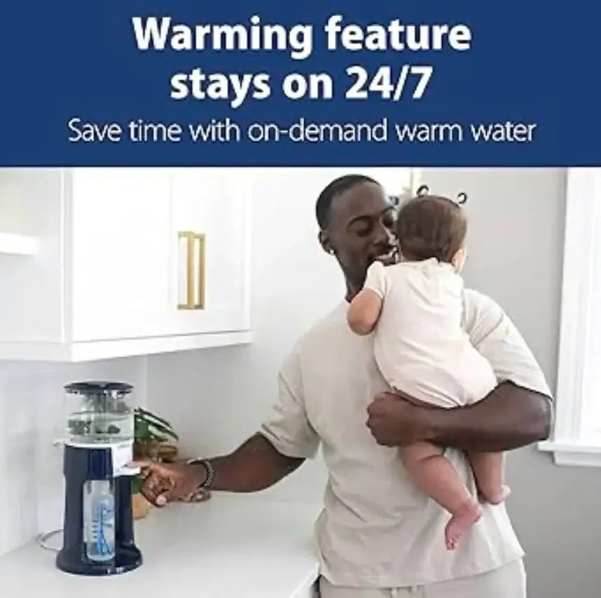 Father holding baby while using a bottle warmer in a modern kitchen