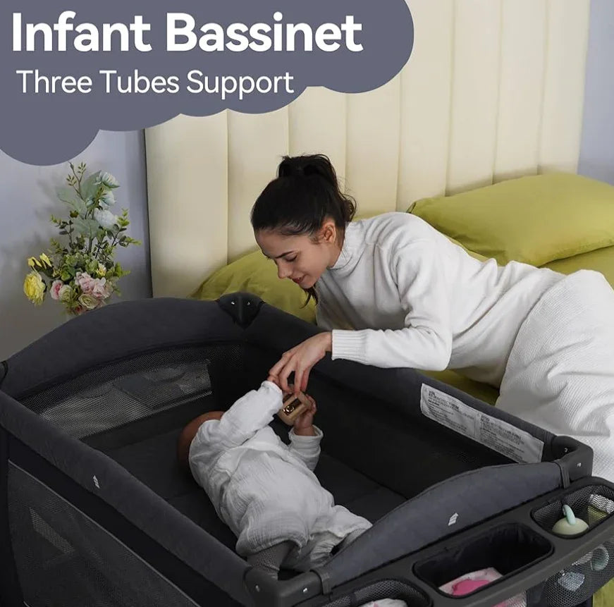 Mother interacting with baby in grey infant bassinet beside yellow bed, three tubes support