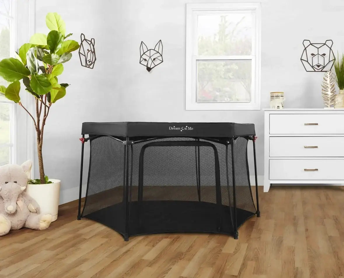Front view of Dream On Me Onyx 6-panel playpen in black showcasing mesh walls and front zipper door indoors