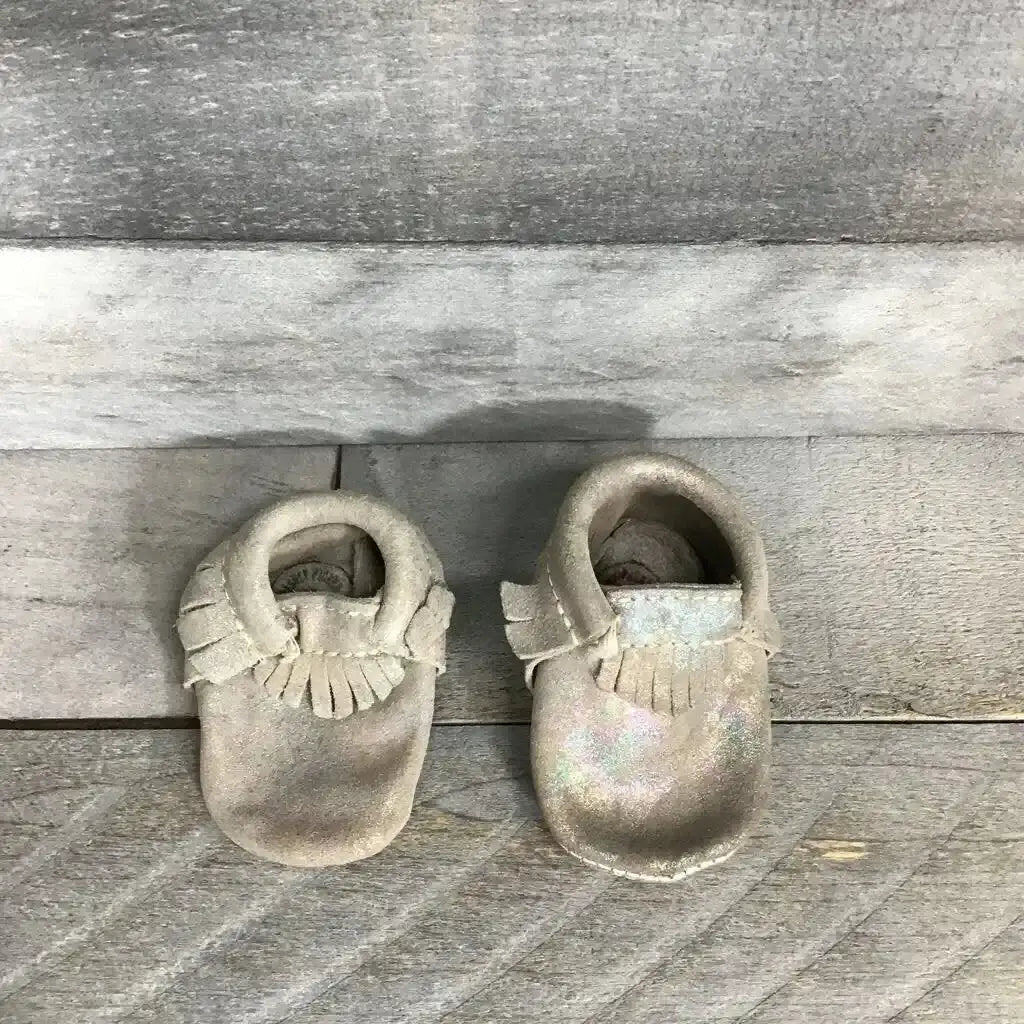 Top view of silver holographic Freshly Picked soft-sole baby moccasins showing iridescent leather and elastic ankle