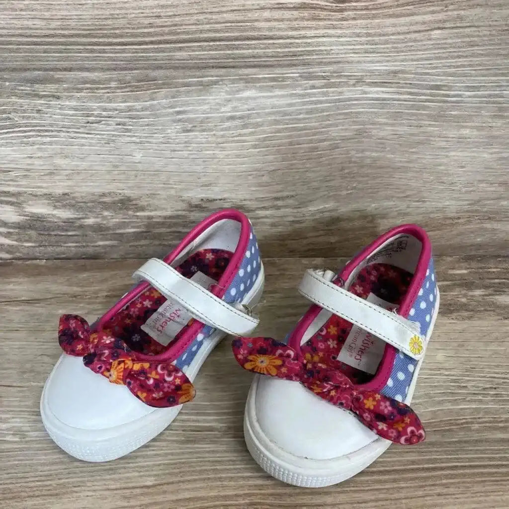 Angled view of American Girl Wellie Wishers shoes with white toe caps, blue polka-dot sides and pink floral bows on wood